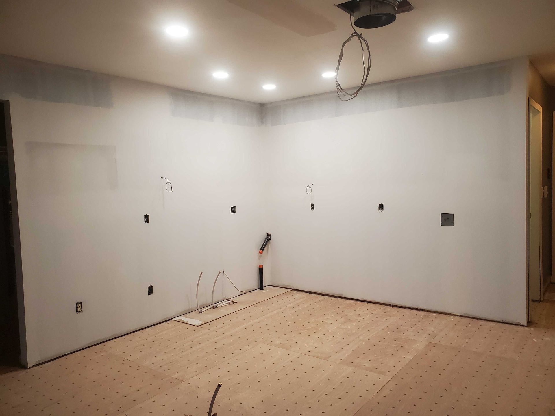 An empty room with a wooden floor and white walls.