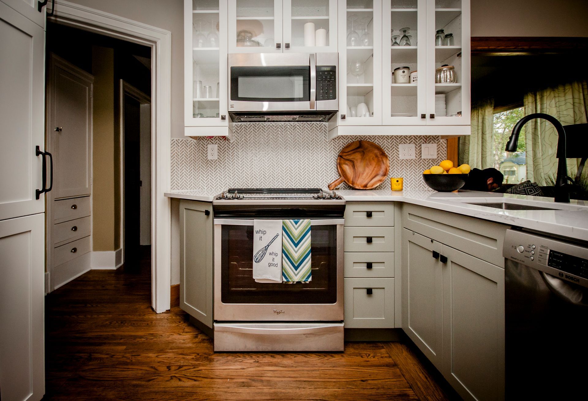 A kitchen with stainless steel appliances and white cabinets.