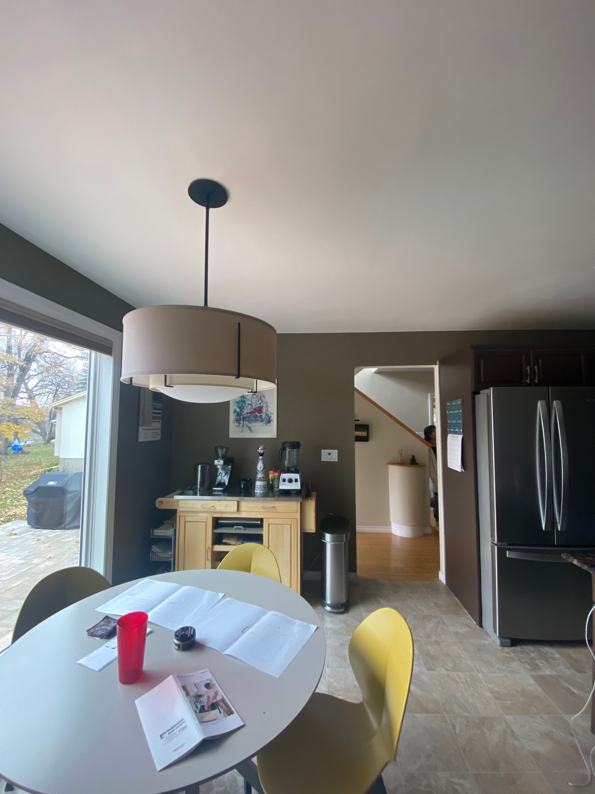 A kitchen with a round table and yellow chairs