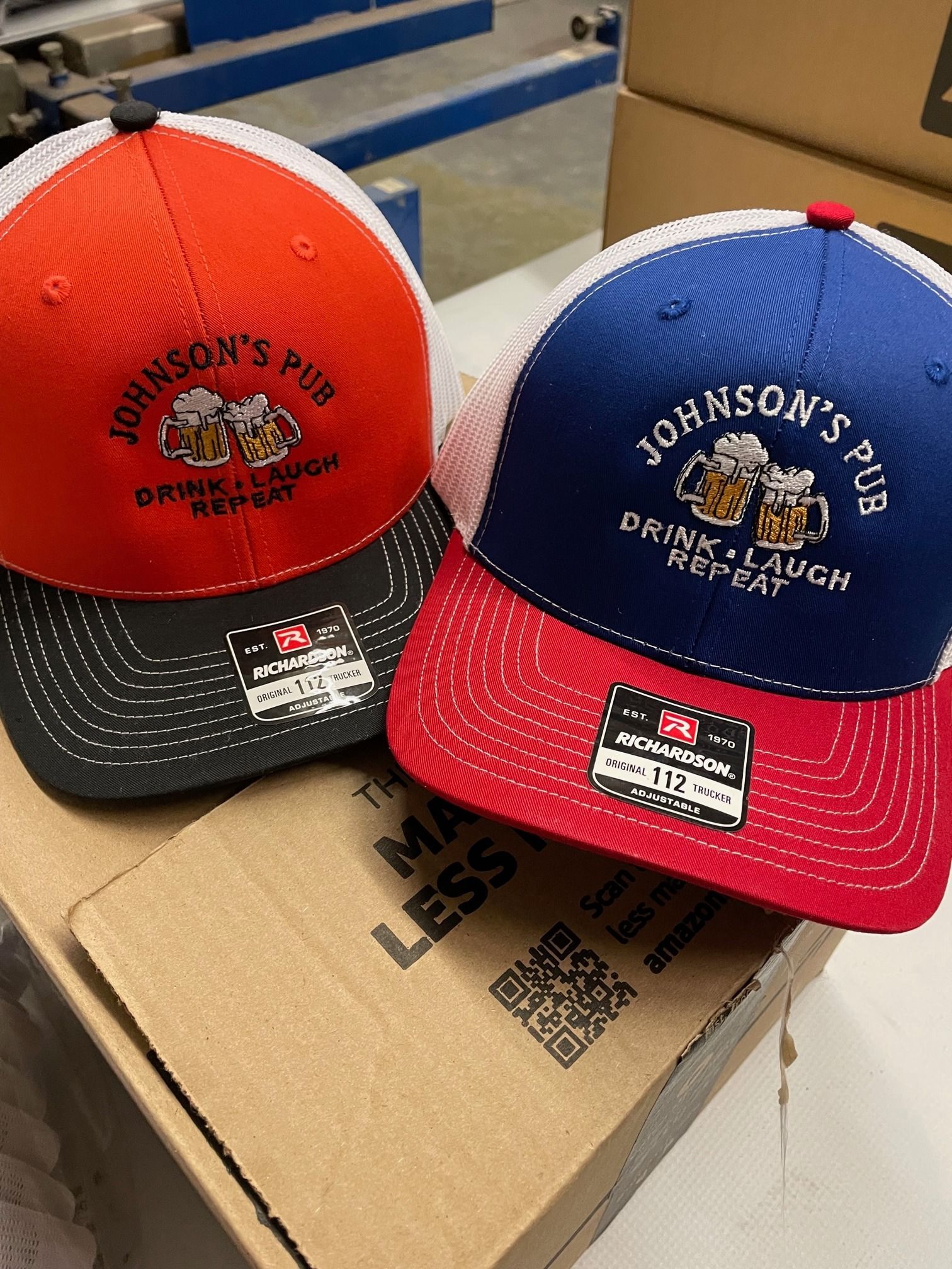 Two hats are sitting on top of a cardboard box.