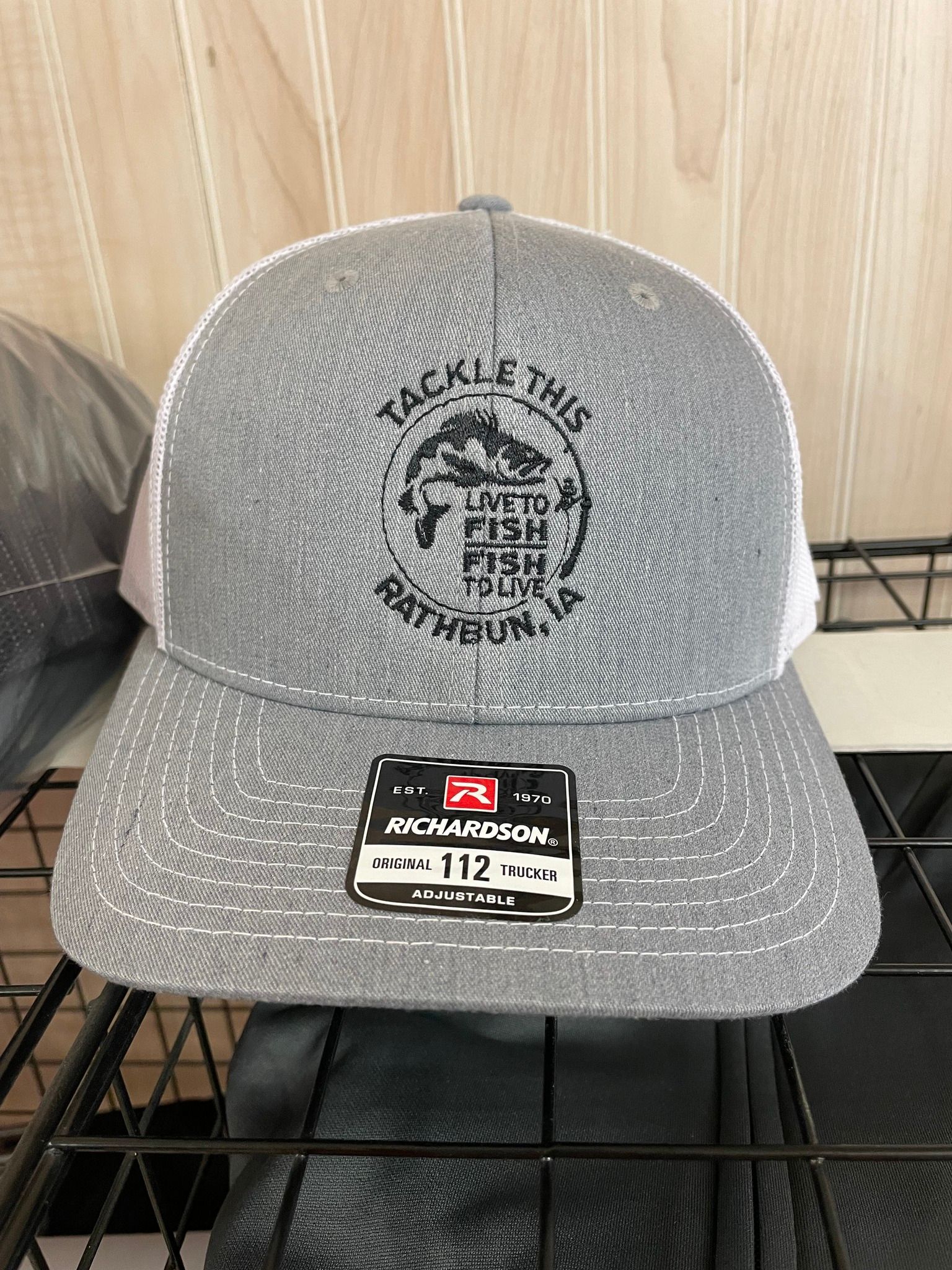 A hat that says tackle this is sitting on a shelf.