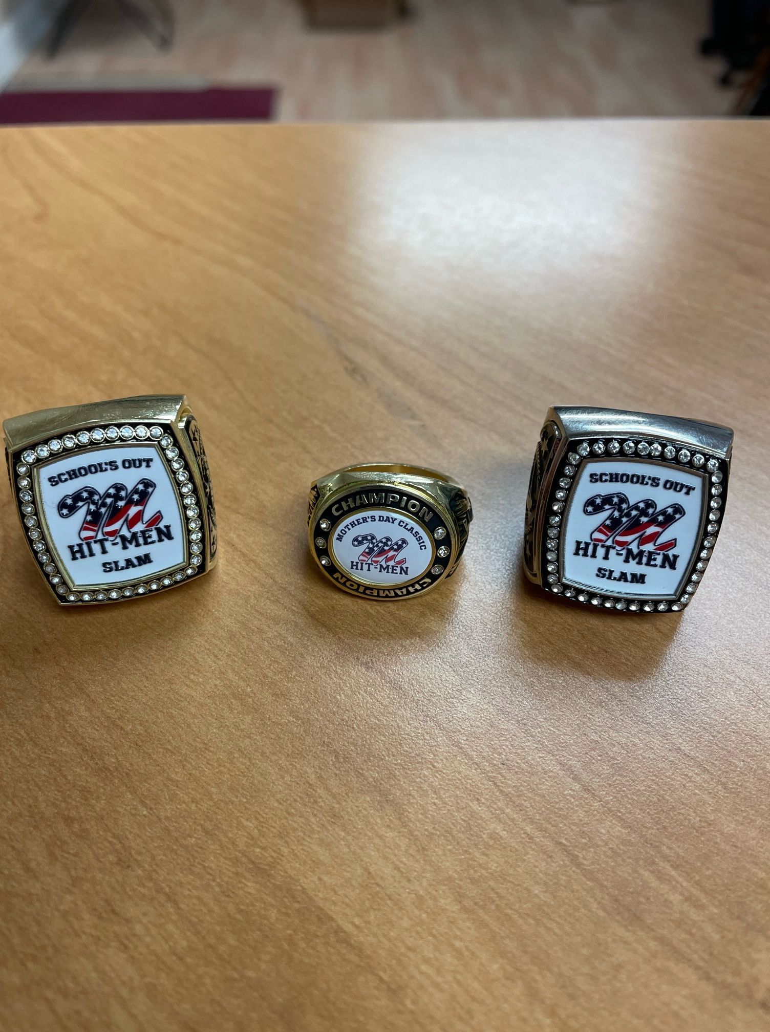 Three rings are sitting on a wooden table.