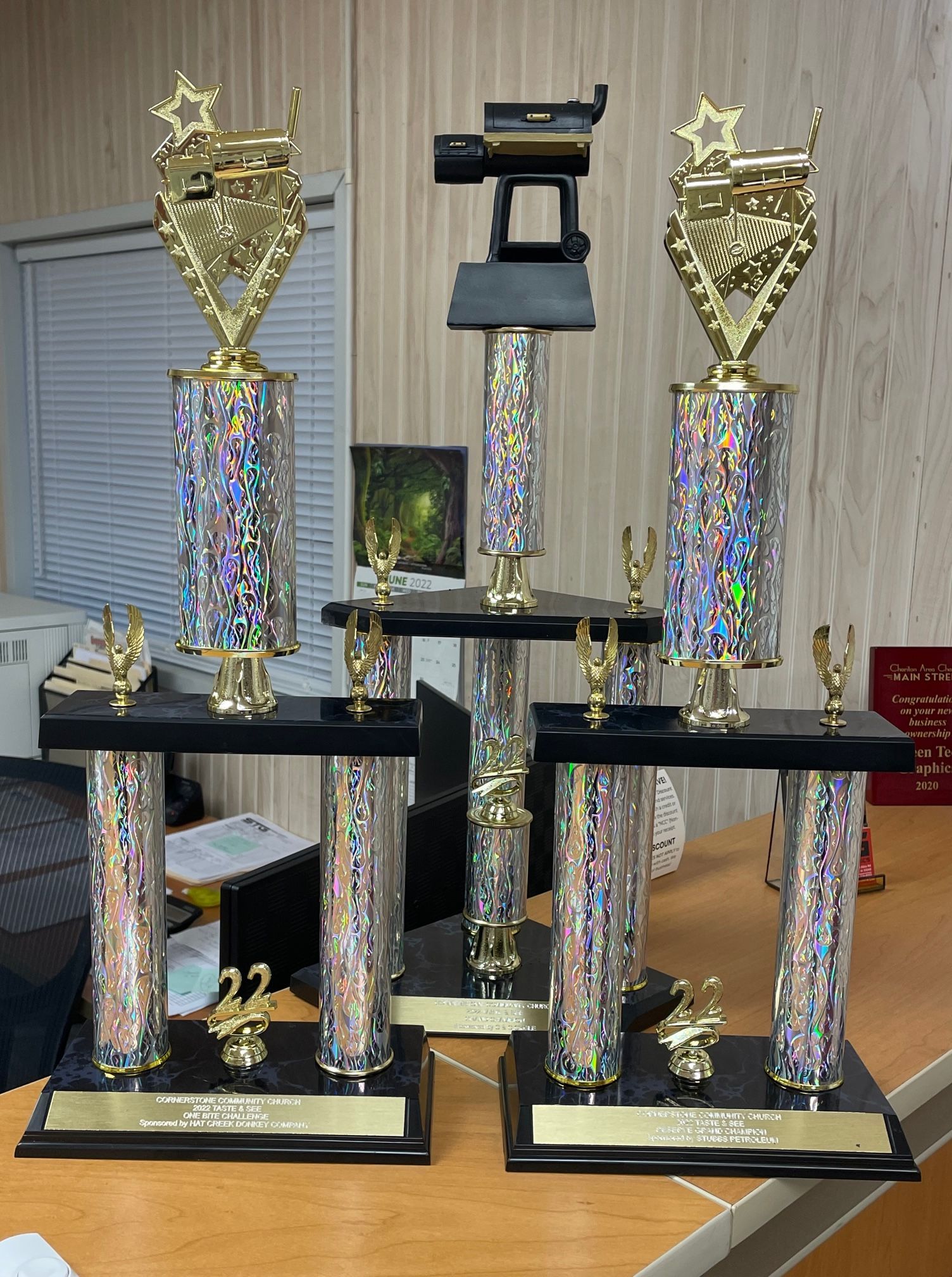 Three trophies are stacked on top of each other on a table