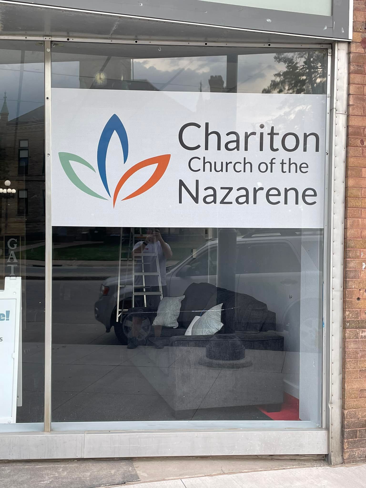 A window with a sign that says ' chariton church of the nazarene ' on it