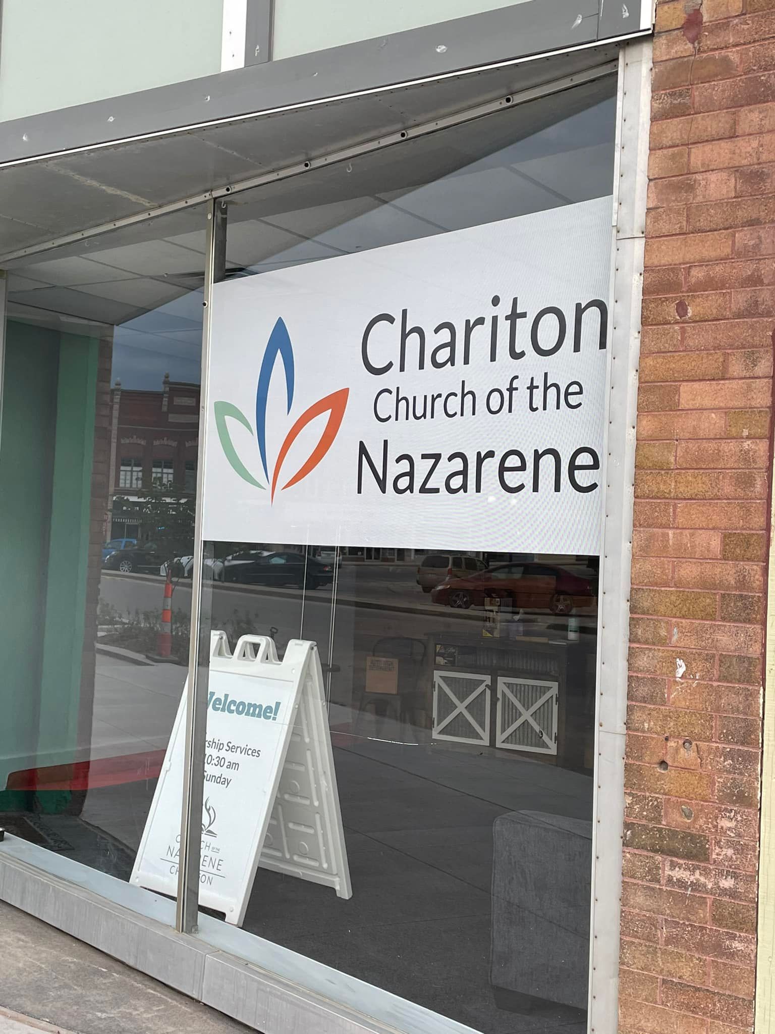 A sign for chariton church of the nazarene is in a window.