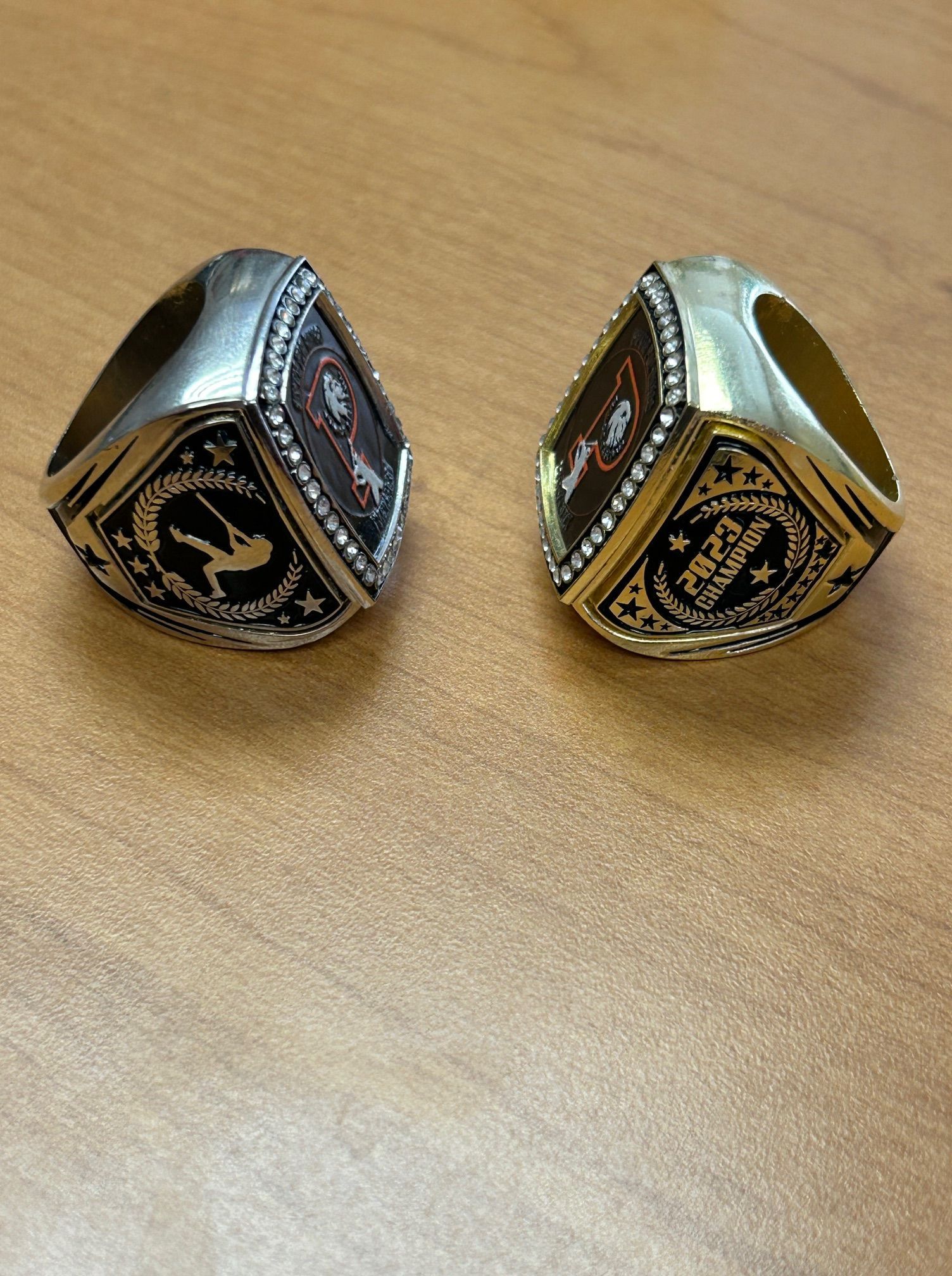 Two rings are sitting on a wooden table.
