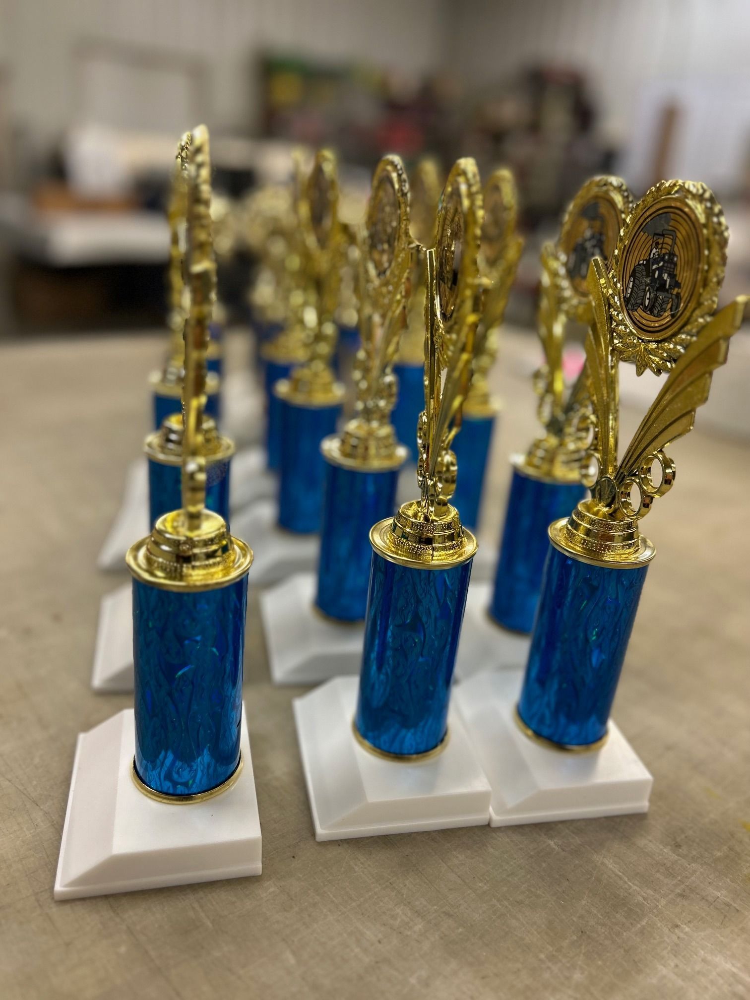 A bunch of blue and gold trophies are sitting on a table.