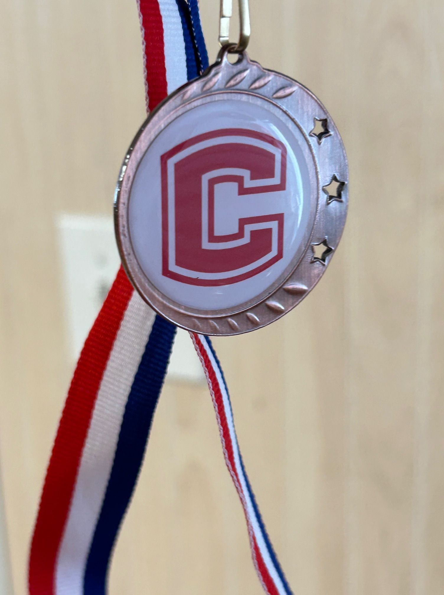 A medal with the letter c on it