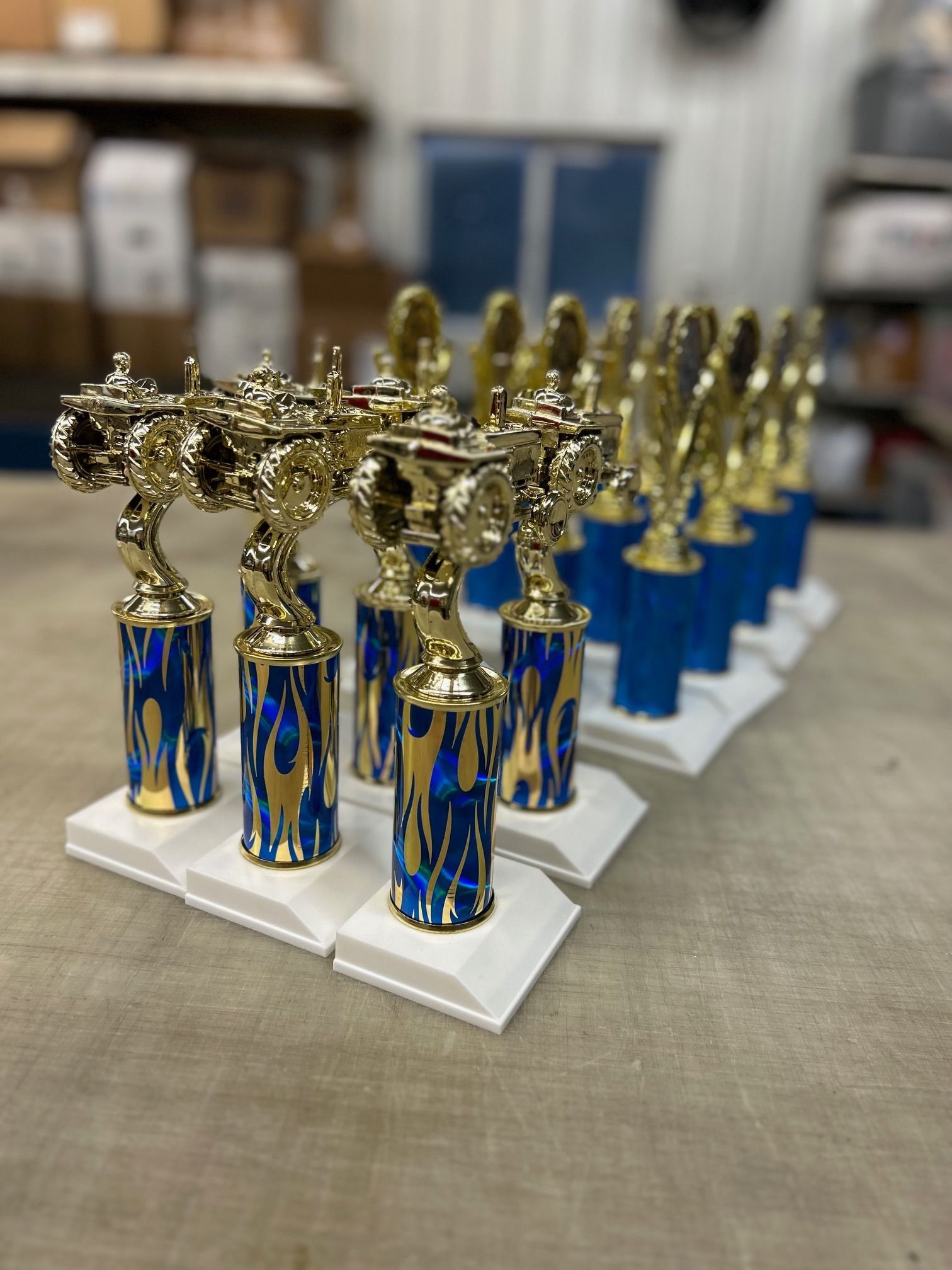 A row of blue and gold trophies are sitting on a table.