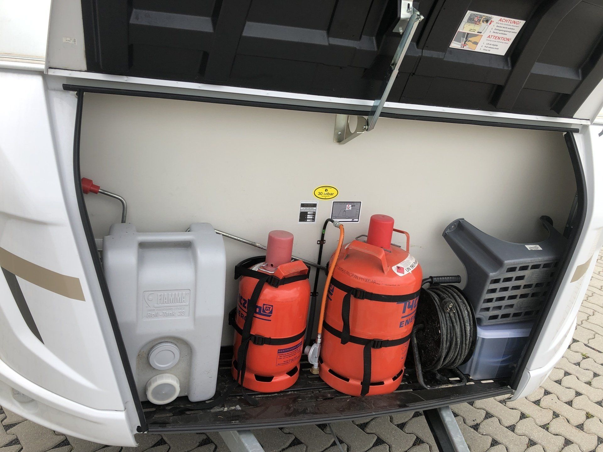 Two gas cylinders are sitting in the back of a trailer.