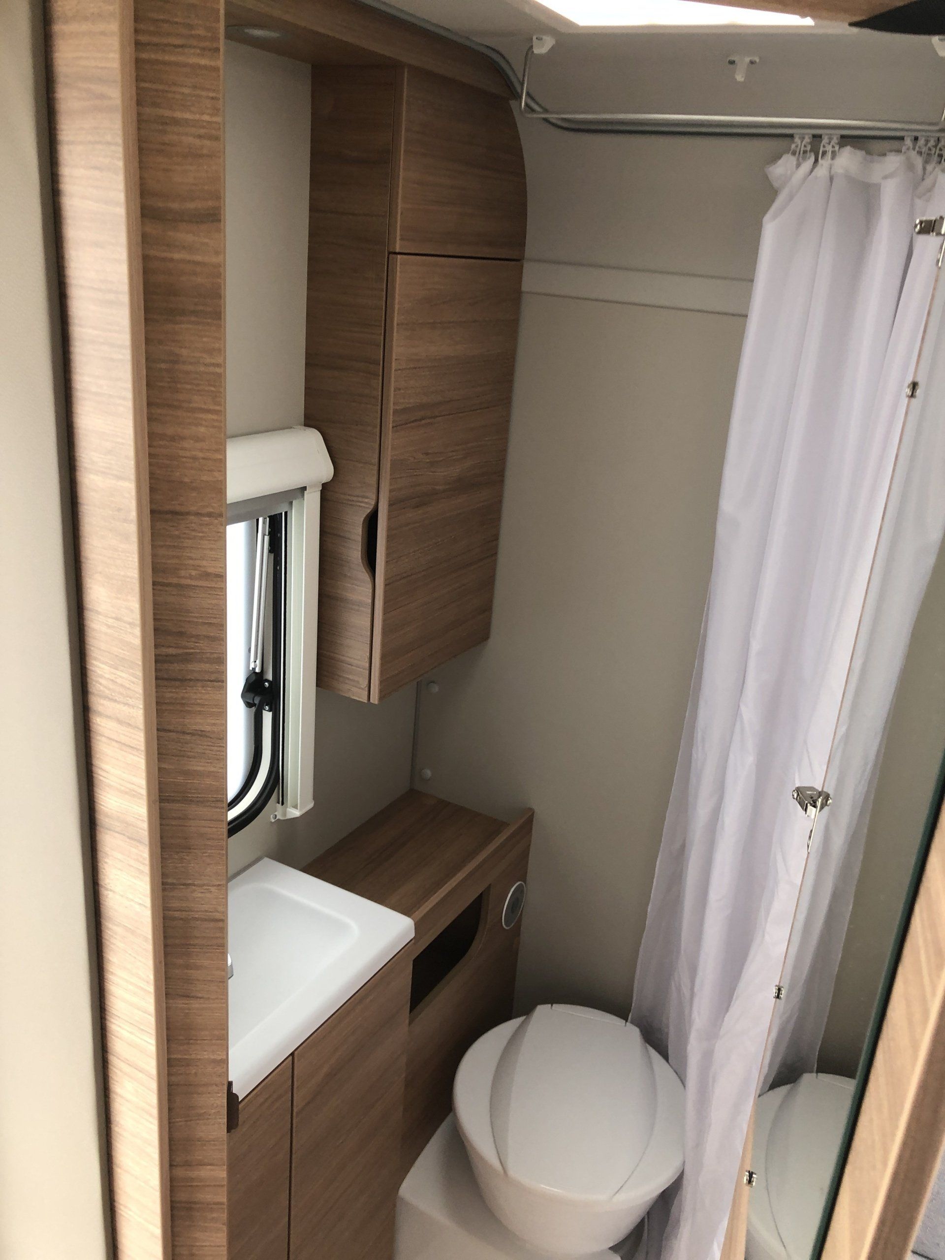 A bathroom with a toilet , sink and shower curtain.