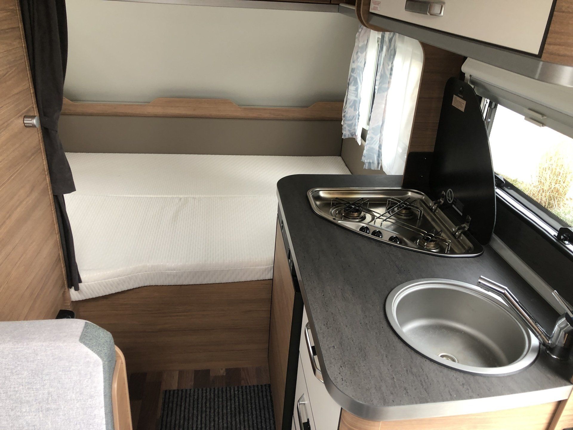 A kitchen in a camper with a sink and stove.