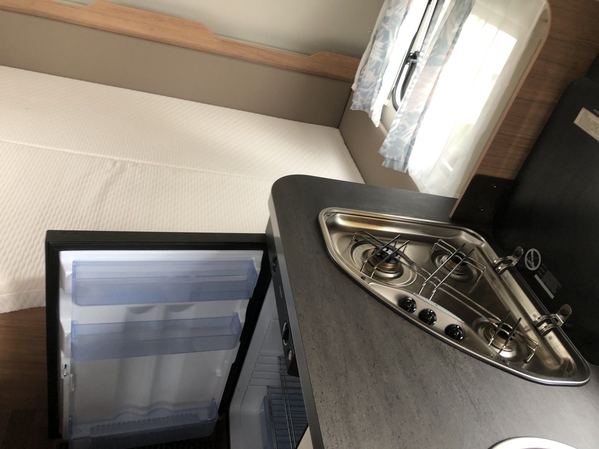 A kitchen with a stove top oven and a refrigerator