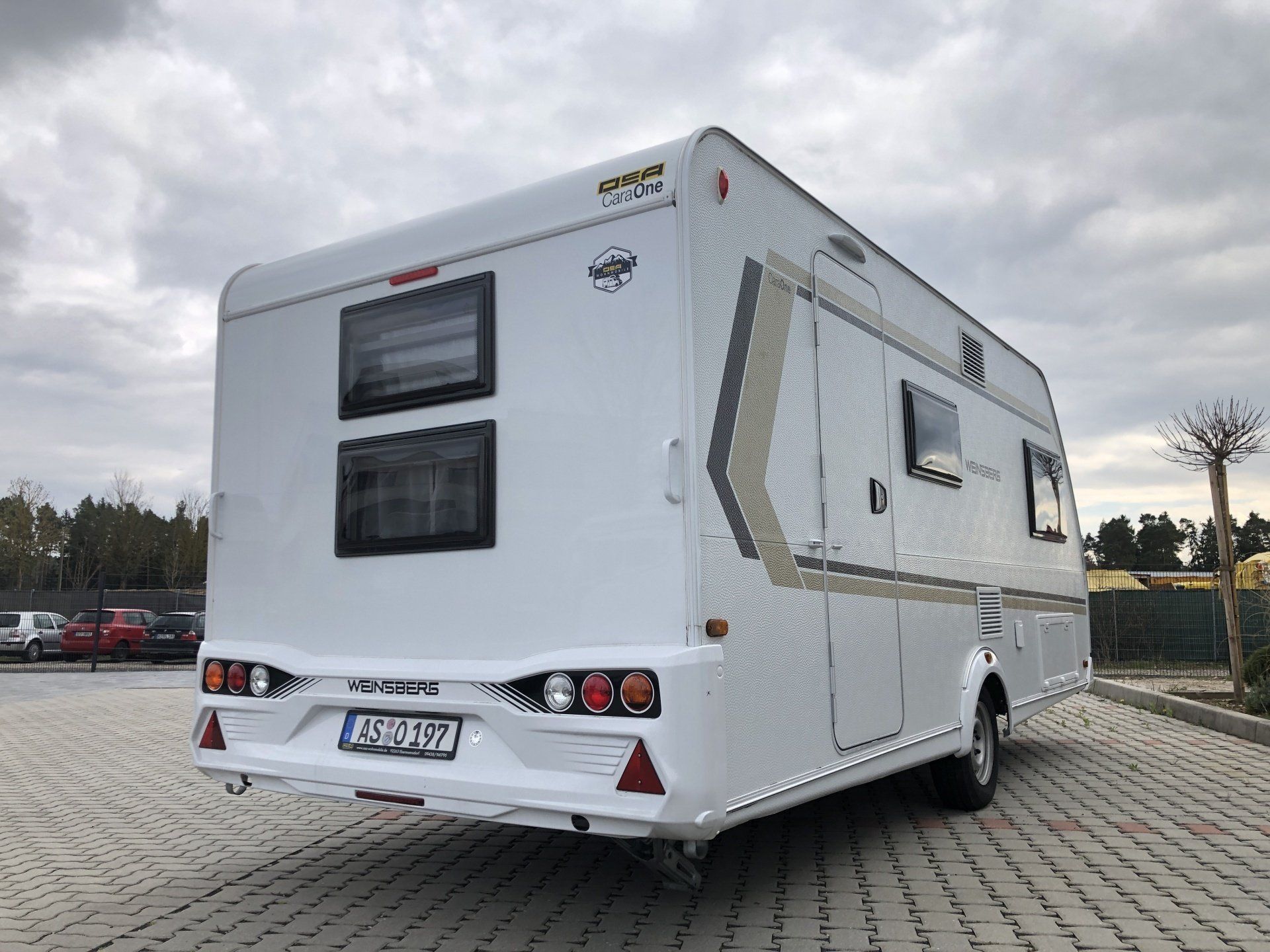 A white rv is parked in a parking lot.