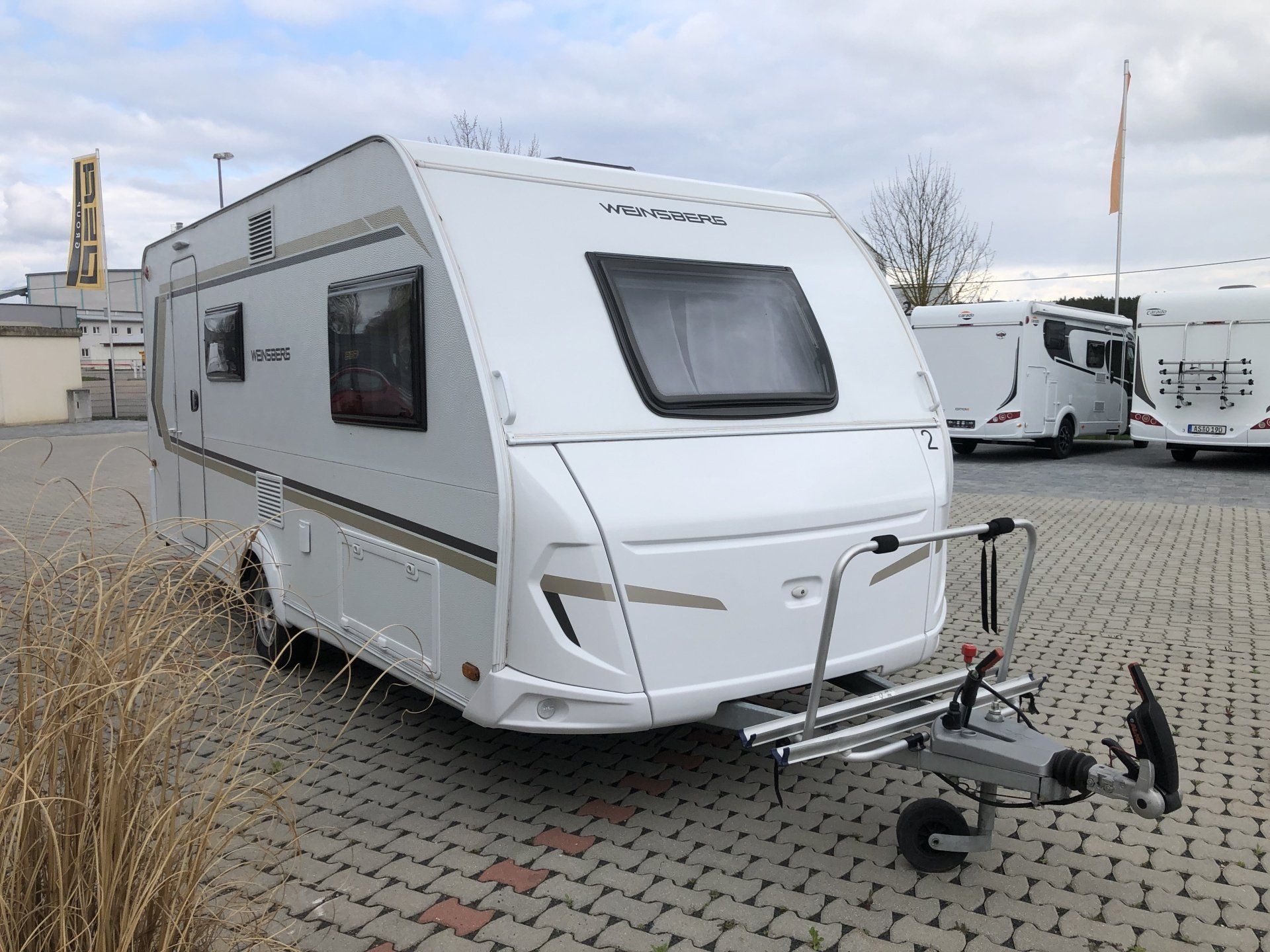 A white caravan is parked in a parking lot.