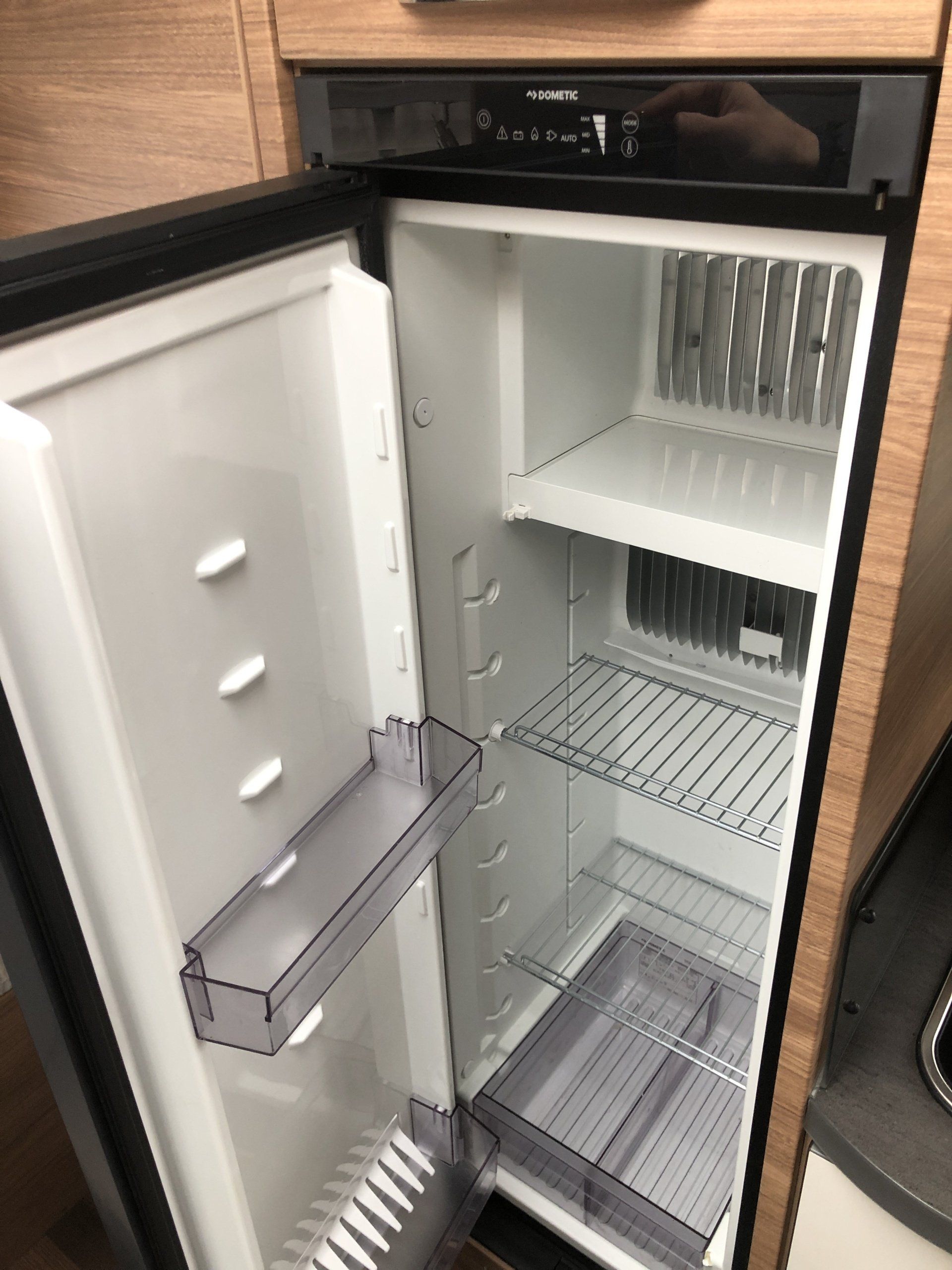 An empty refrigerator with the door open in a kitchen
