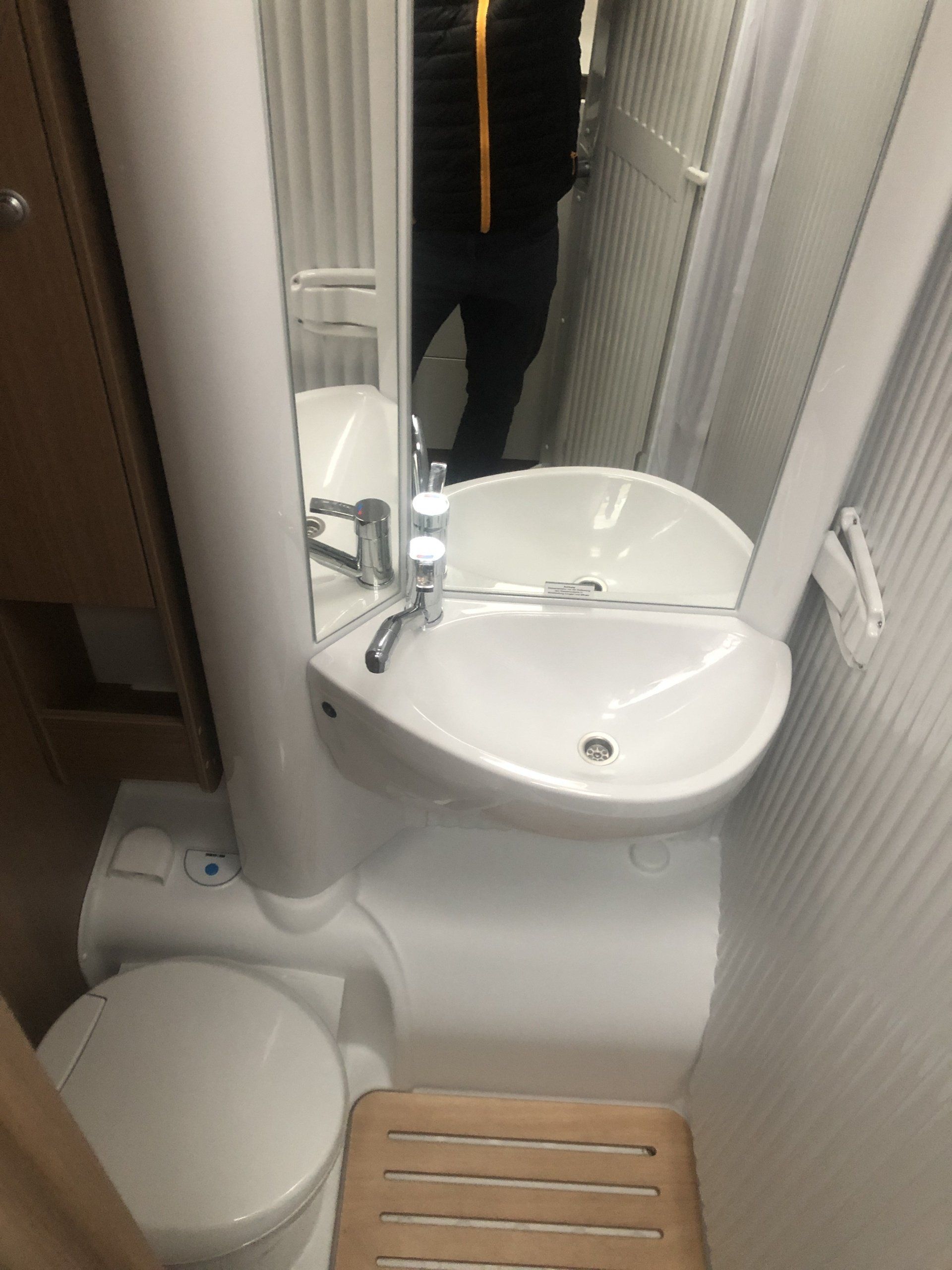 A bathroom with a sink , toilet and mirror.