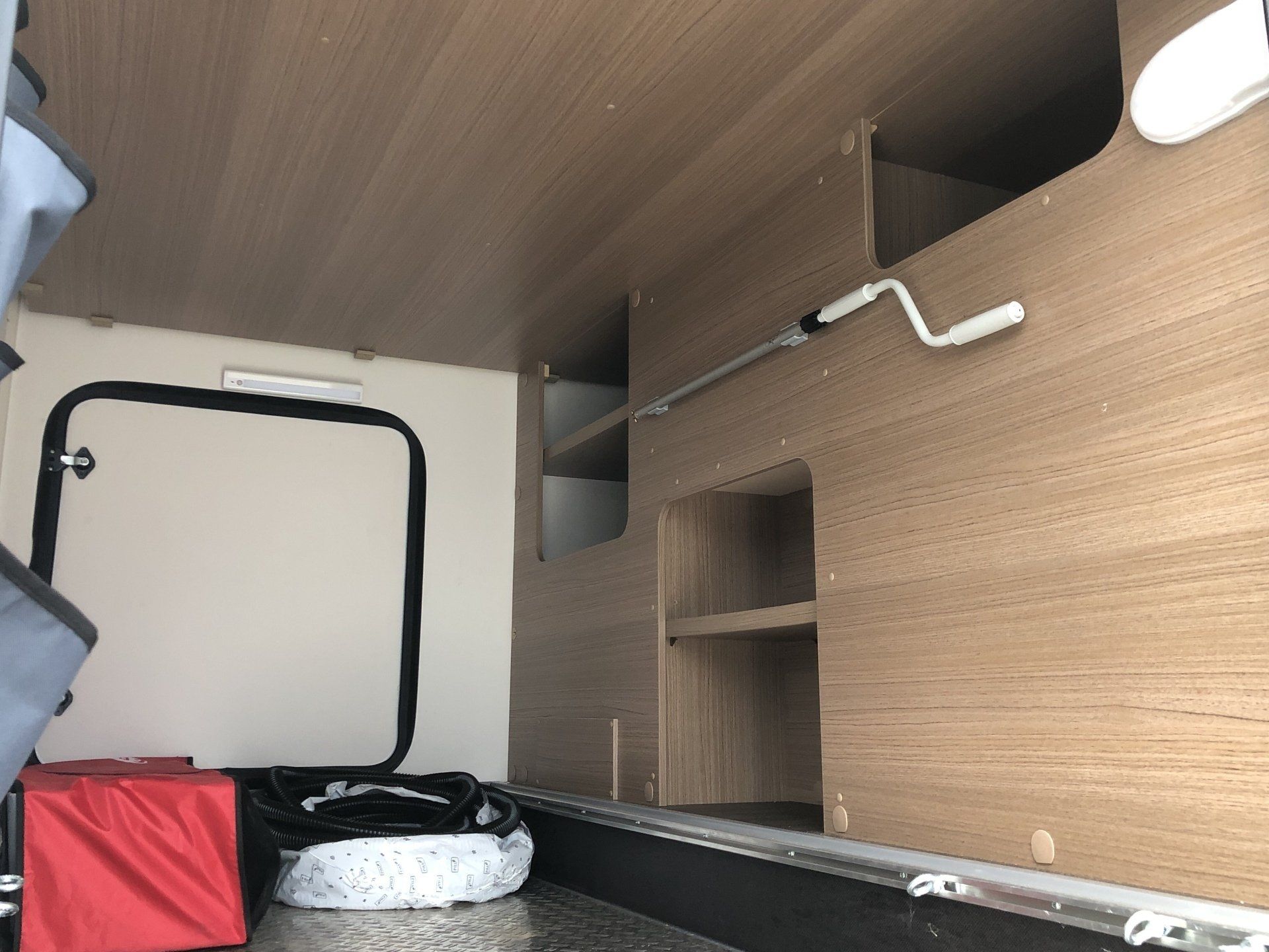 Das Innere eines Wohnmobils mit Holzschränken und Regalen.