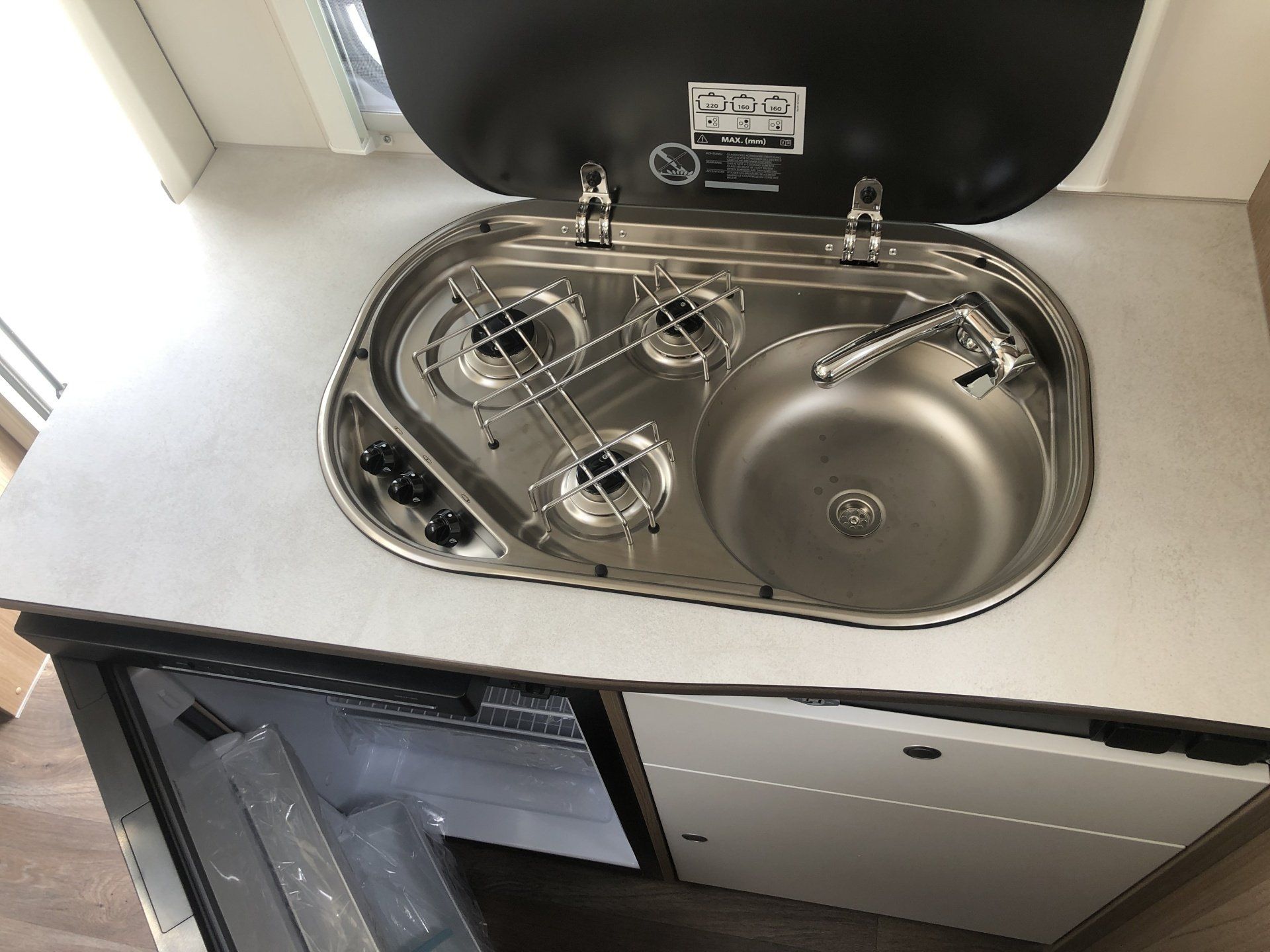 A kitchen counter with a sink stove and refrigerator