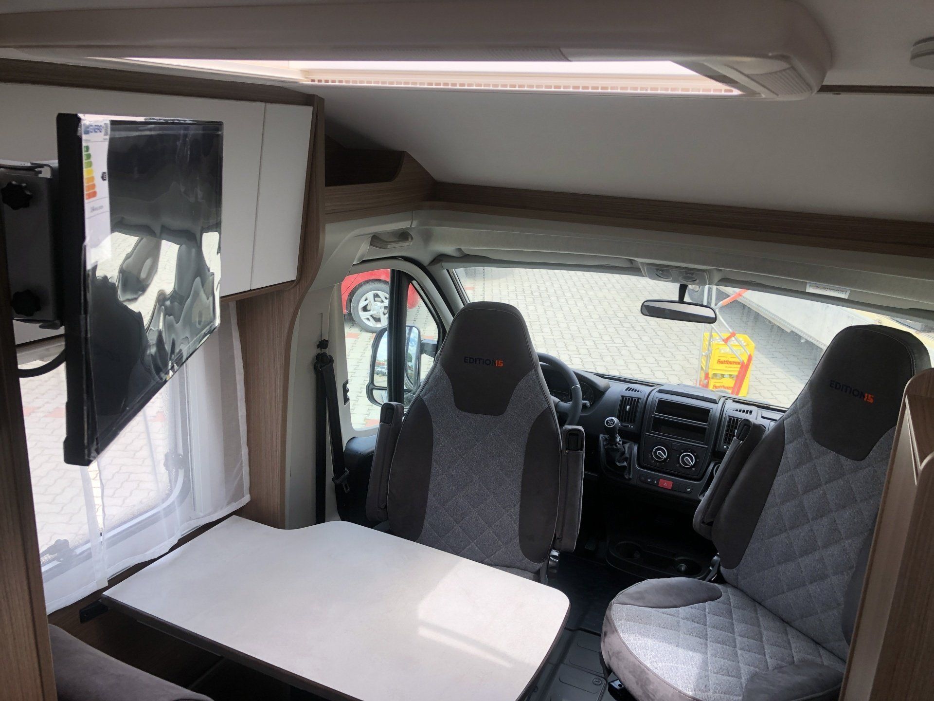 The inside of a camper van with a table and chairs.