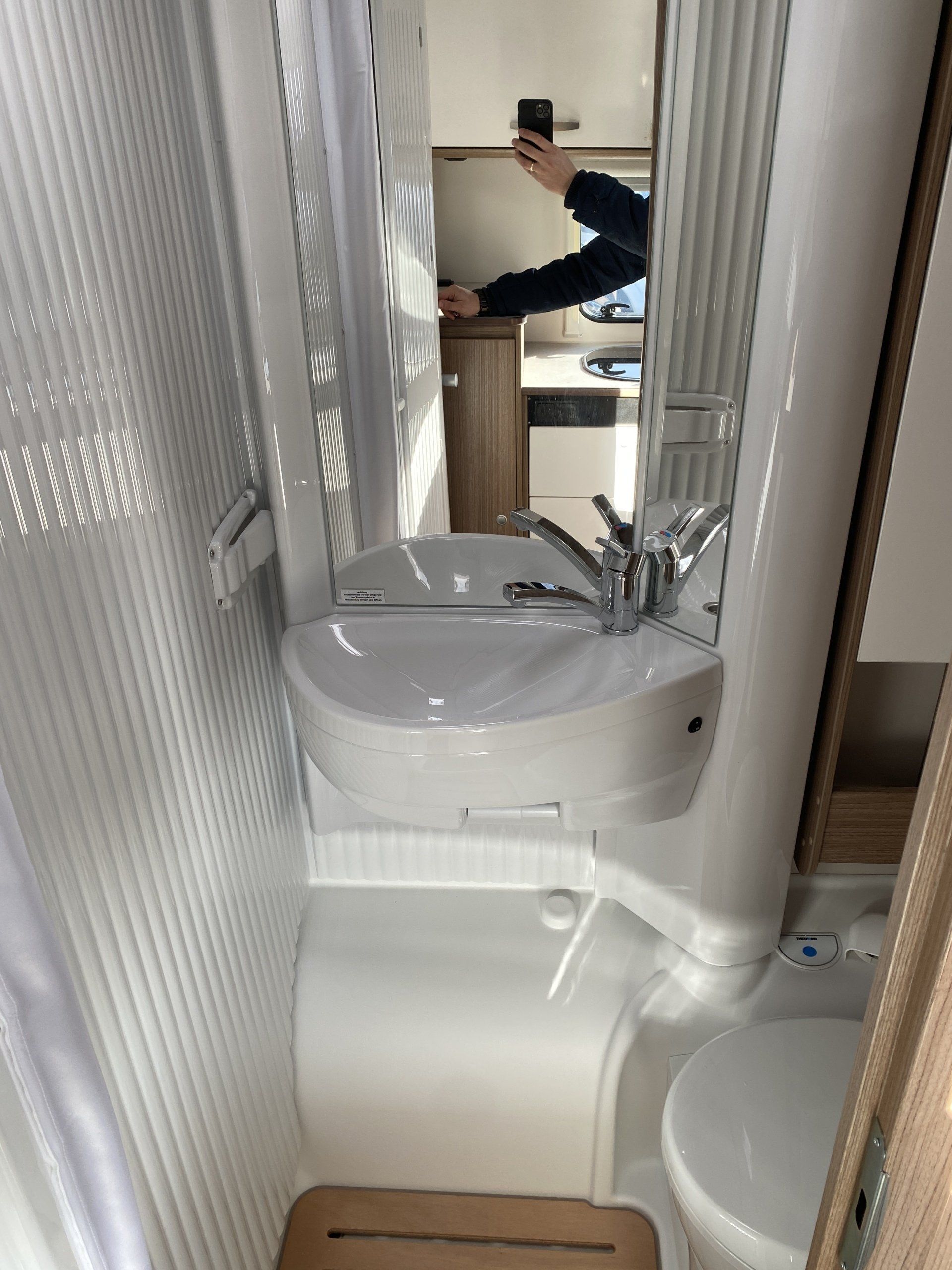 A bathroom with a sink , toilet and mirror.