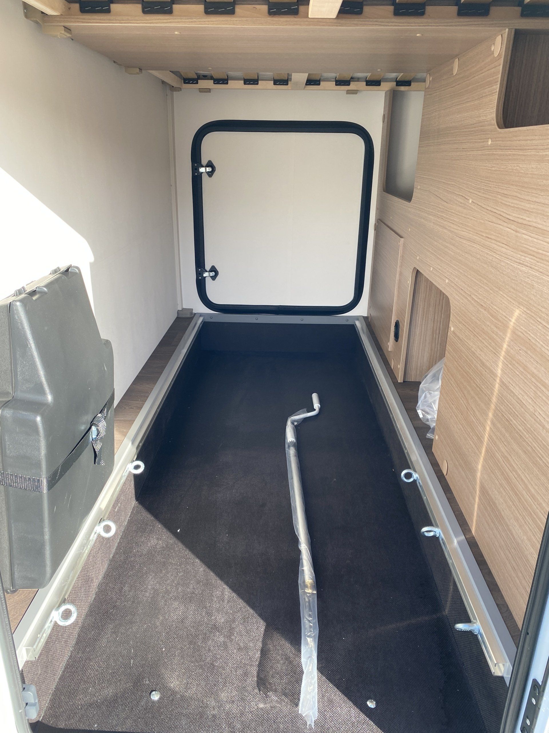 The inside of a camper with a door and a carpeted floor.