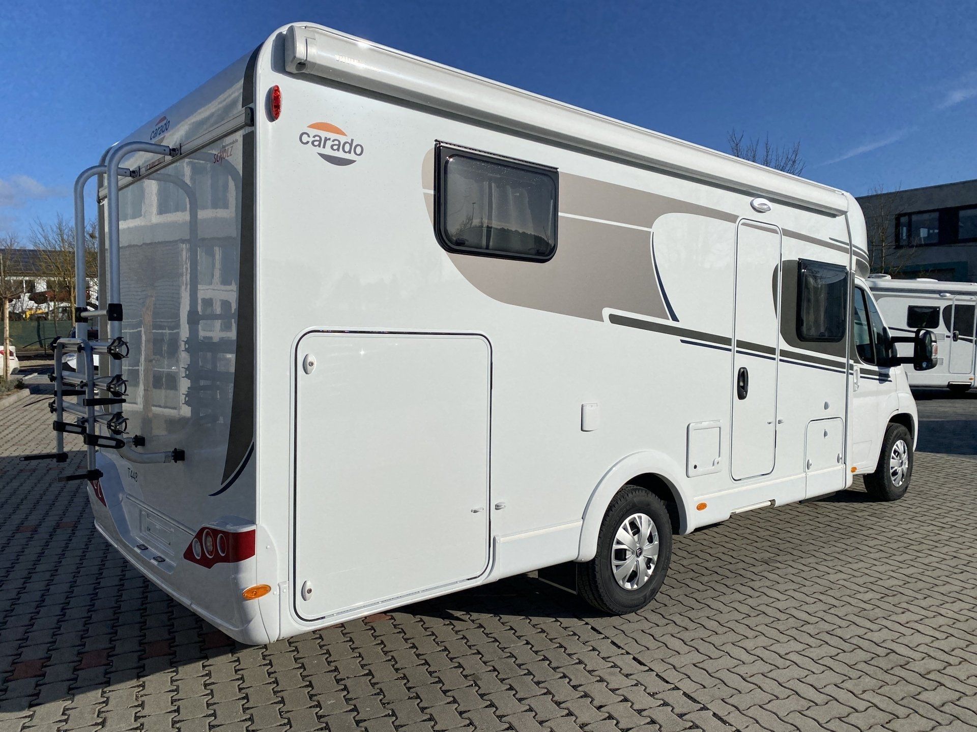 A white rv is parked in a parking lot.