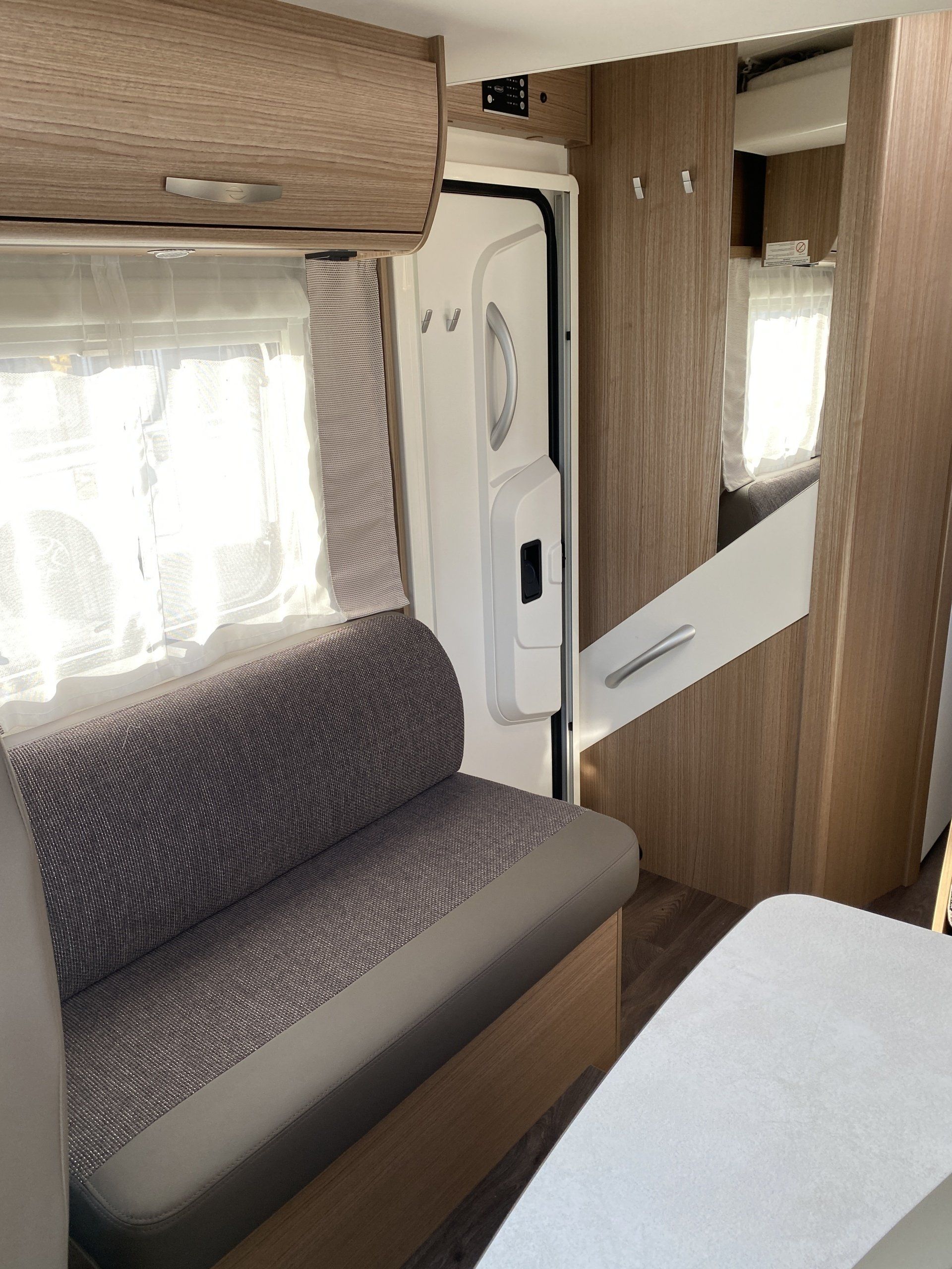 The inside of a camper with a couch and a table.