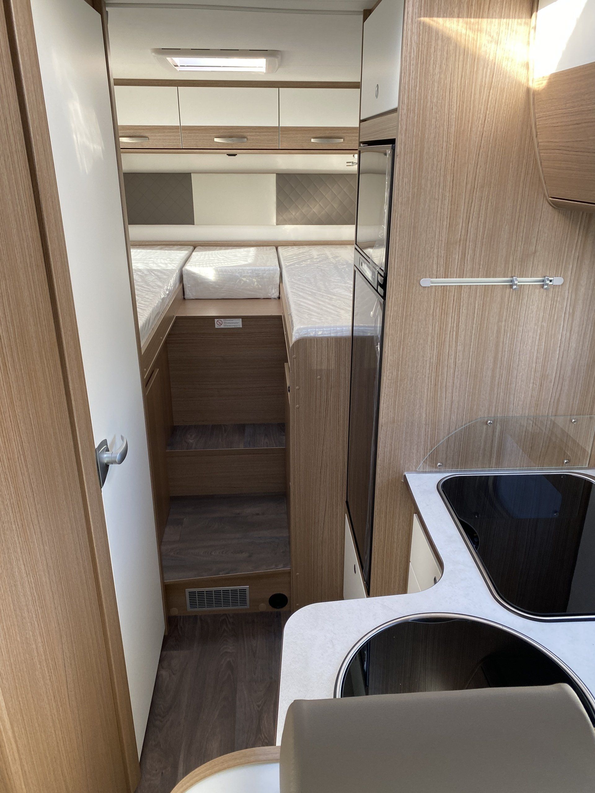 A kitchen in a camper with a stove and sink