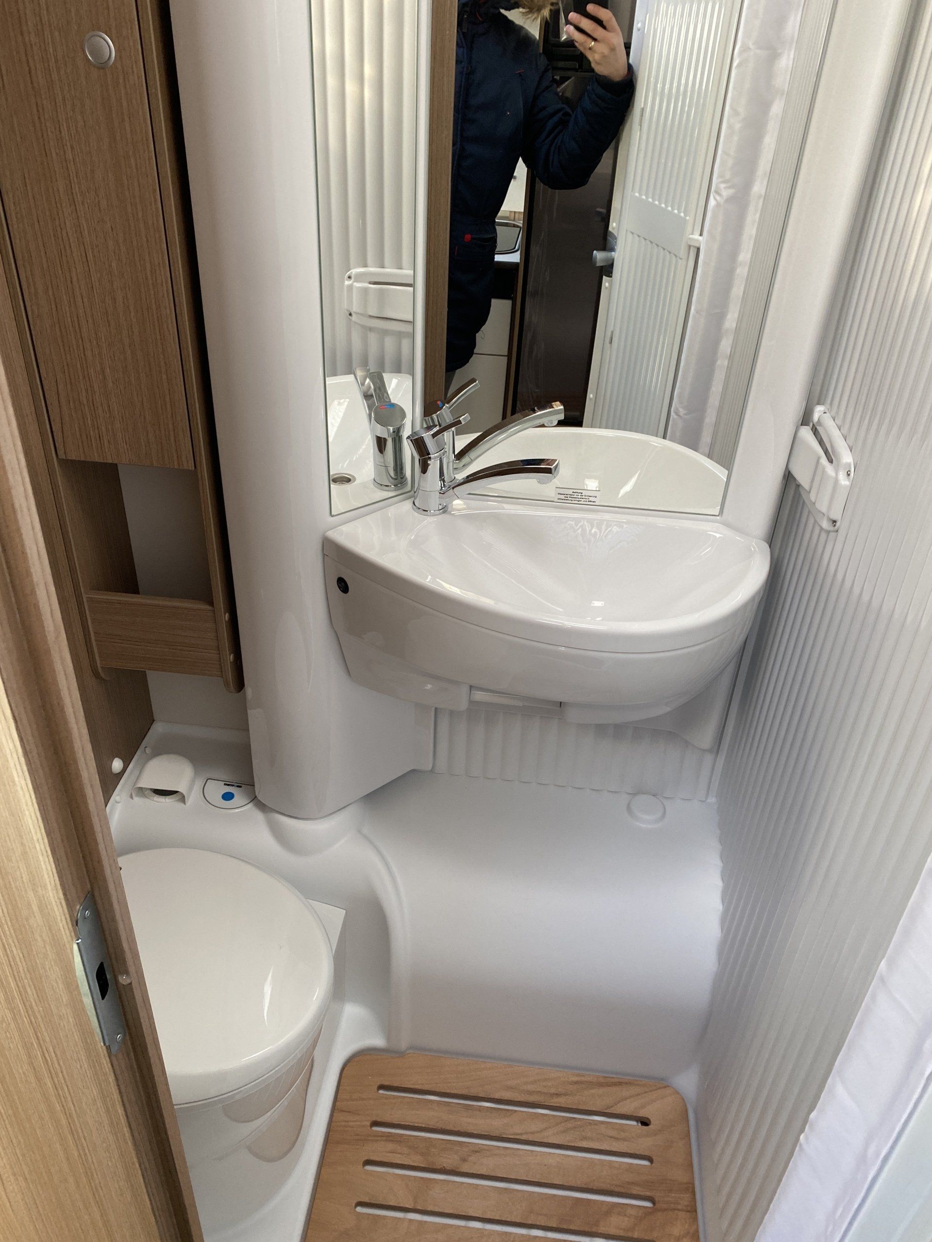 A bathroom with a sink , toilet and mirror.