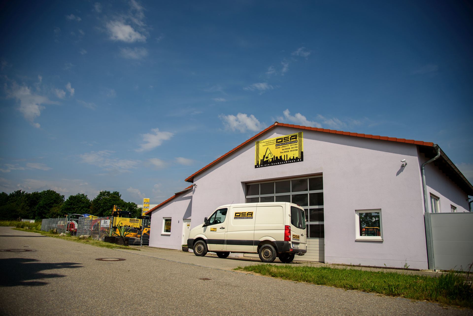 Ein weißer Lieferwagen parkt vor einem violetten Gebäude.