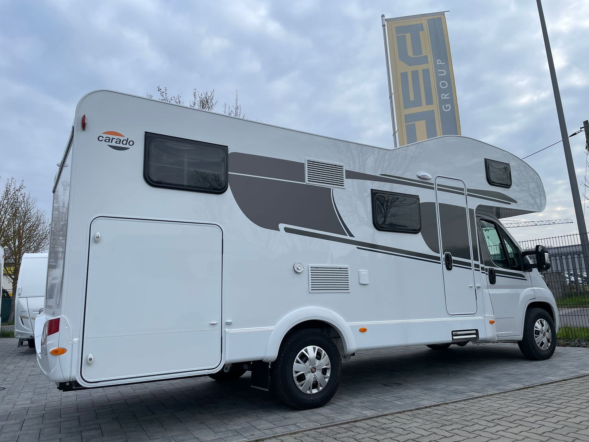 A white camper van is parked in front of a building.