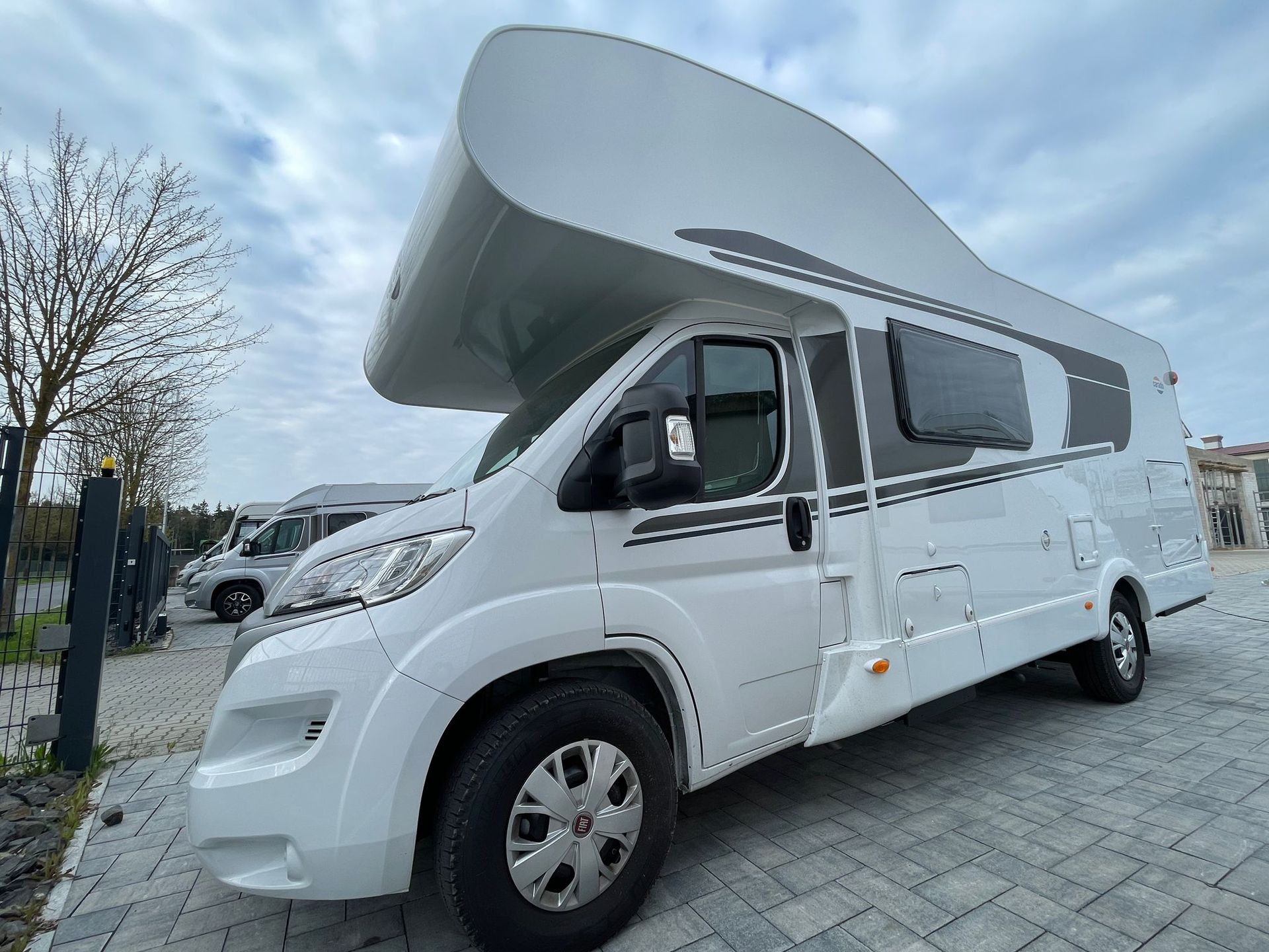 A white camper van is parked in a parking lot.