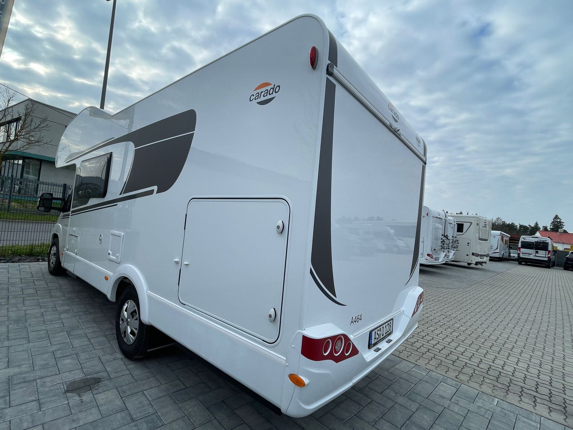 A white rv is parked in a parking lot.
