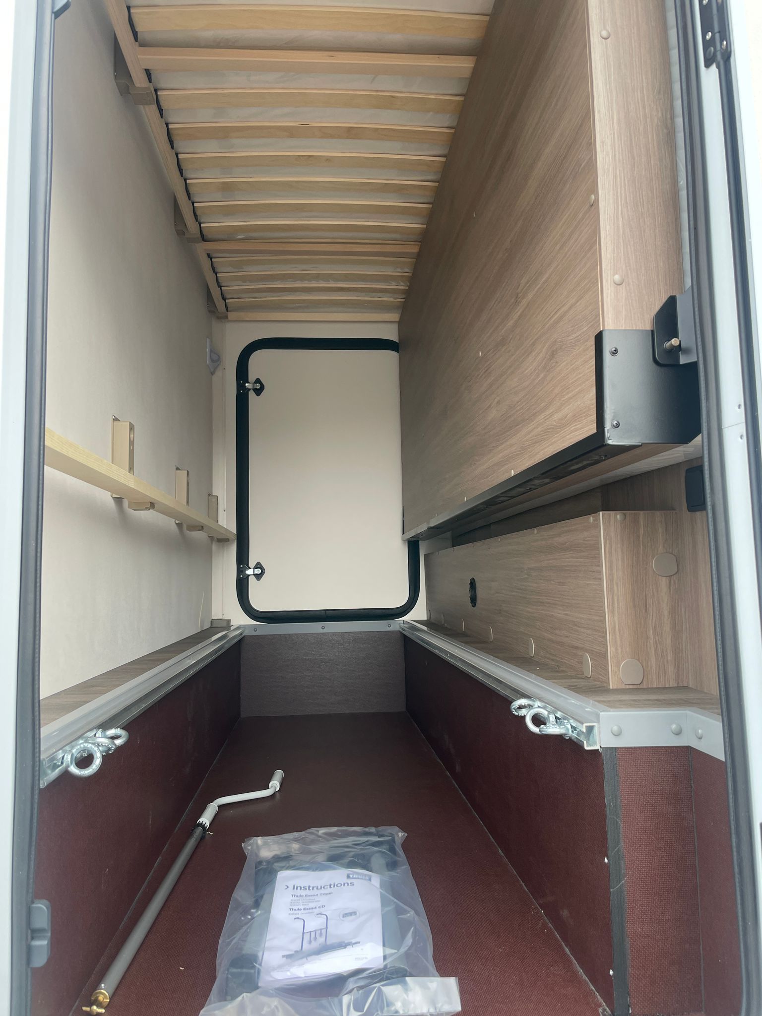 Das Innere eines Wohnmobils mit einem Bett und einer Tür.