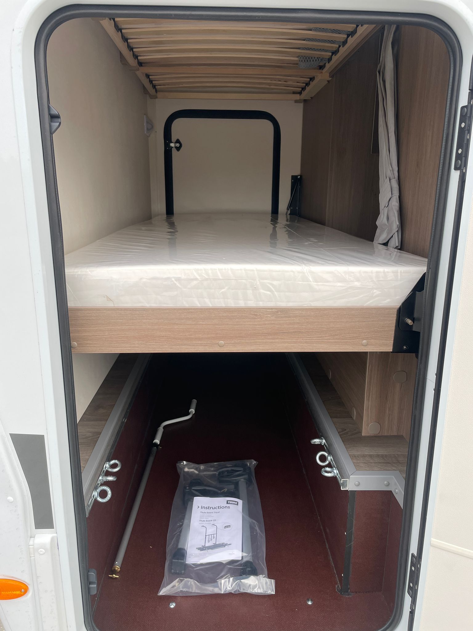 Im hinteren Teil eines Wohnmobils befindet sich ein Bett.