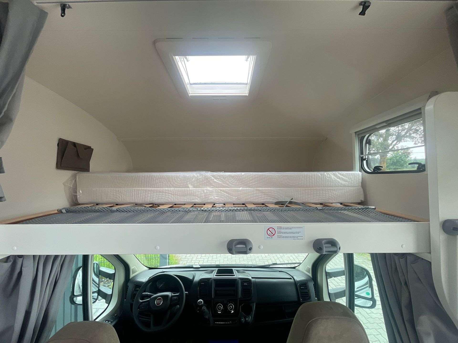 Das Innere eines Autos mit einem Etagenbett und einer Matratze.