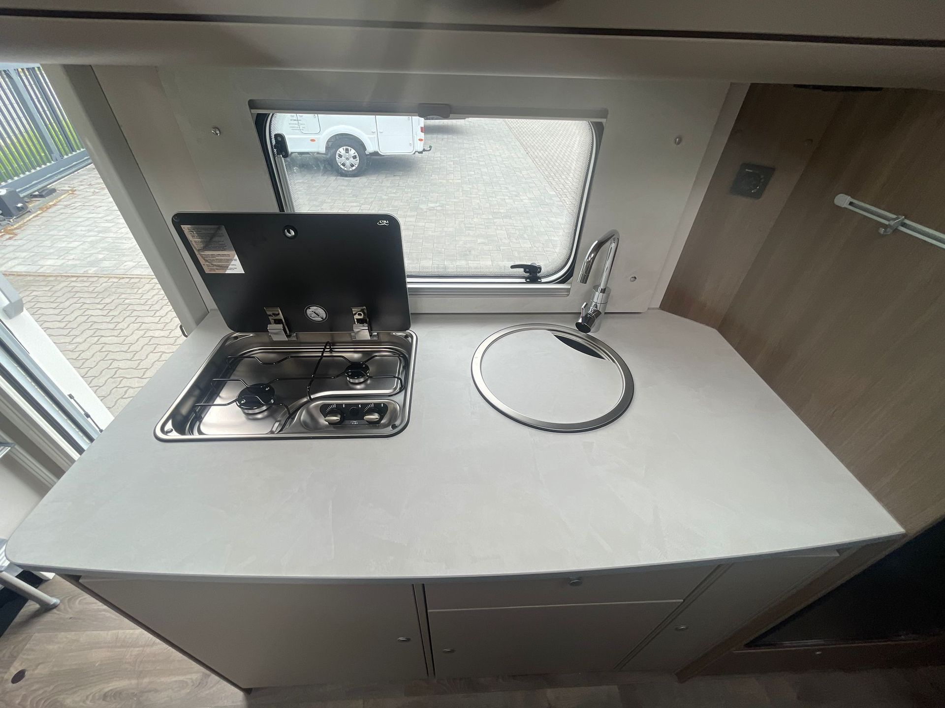 Eine Küche im Wohnmobil mit Spüle und Herd mit Backofen.