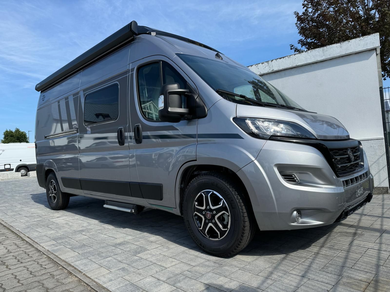 Ein weißer Lieferwagen steht vor einem Gebäude.