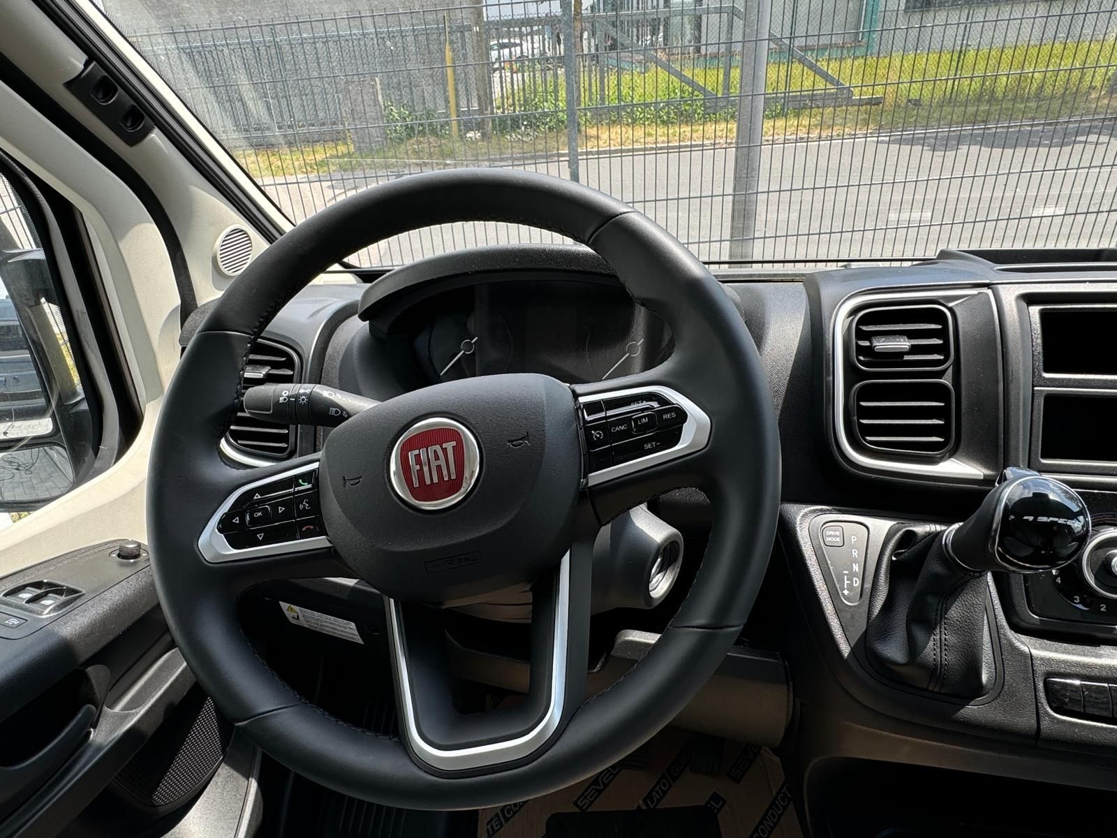 Schwarzes Fiat-Lenkrad mit silbernen Akzenten im Fahrzeuginnenraum.