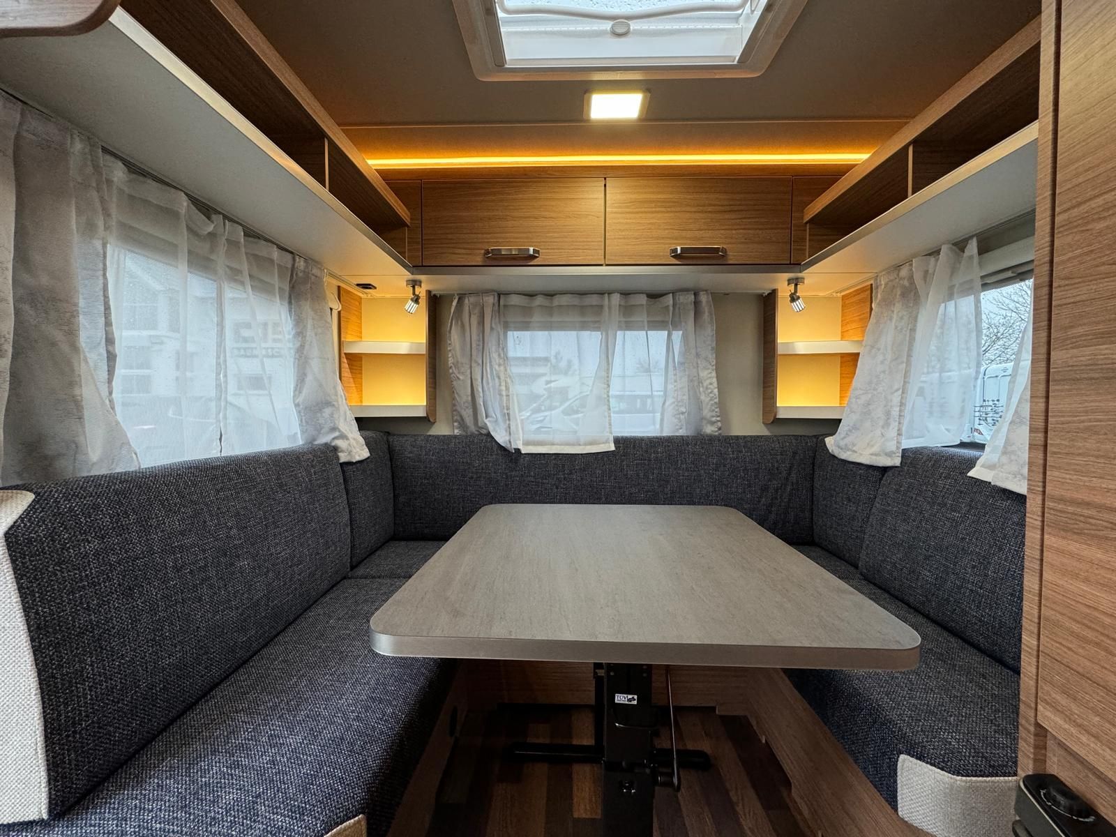 Der Innenraum eines Wohnmobils mit Tisch und Couch.