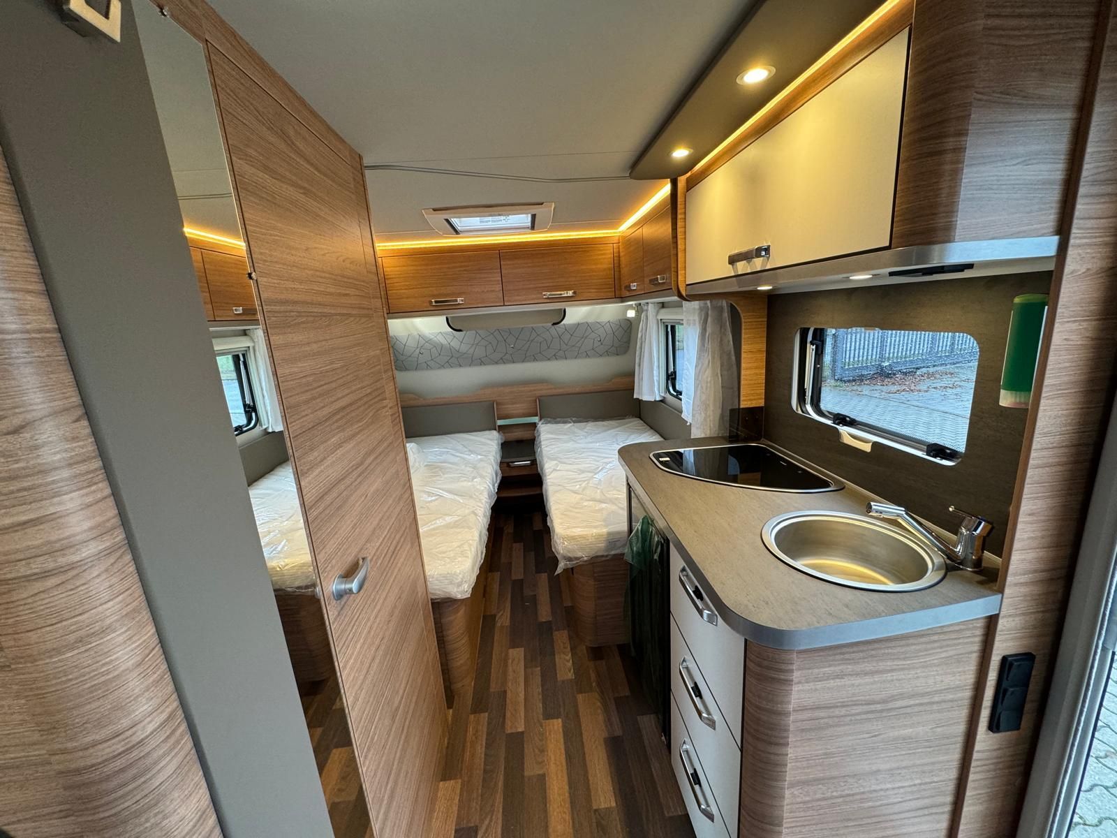 Eine Küche im Wohnmobil mit zwei Betten und einer Spüle.