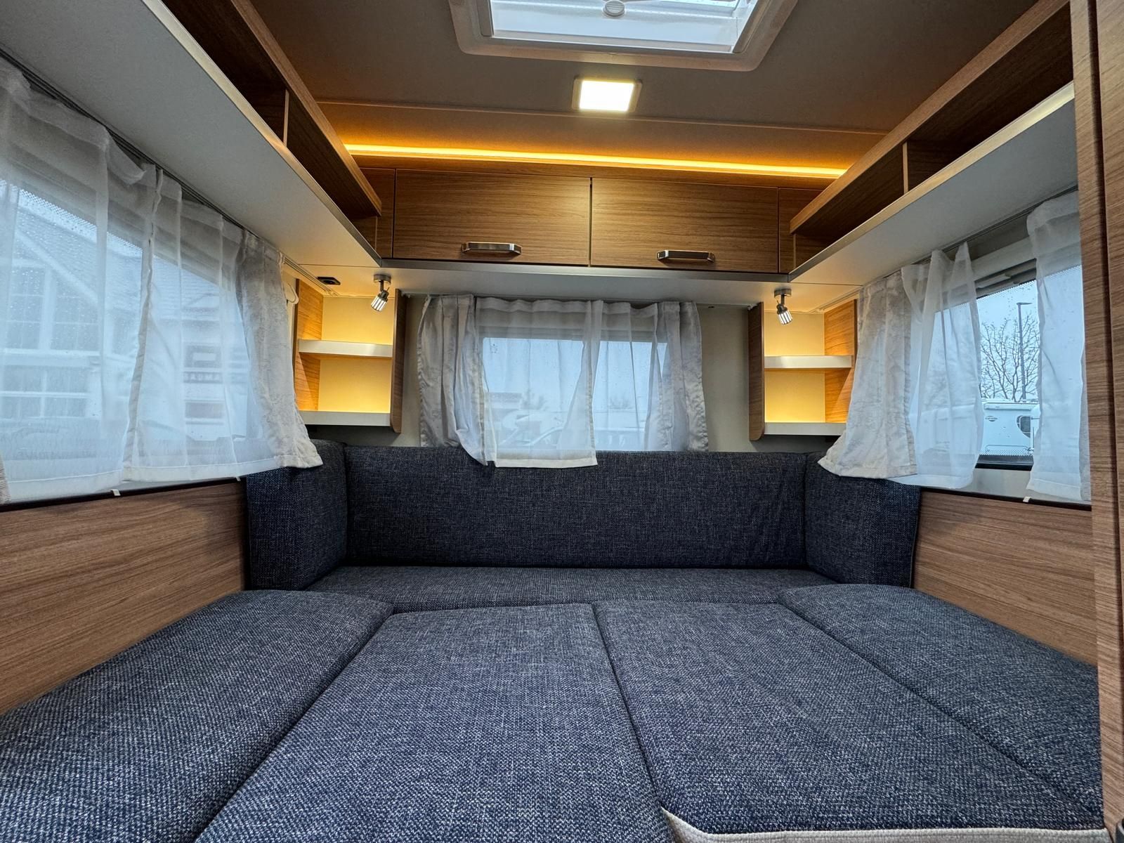 Das Innere eines Wohnmobils mit Couch und Vorhängen.