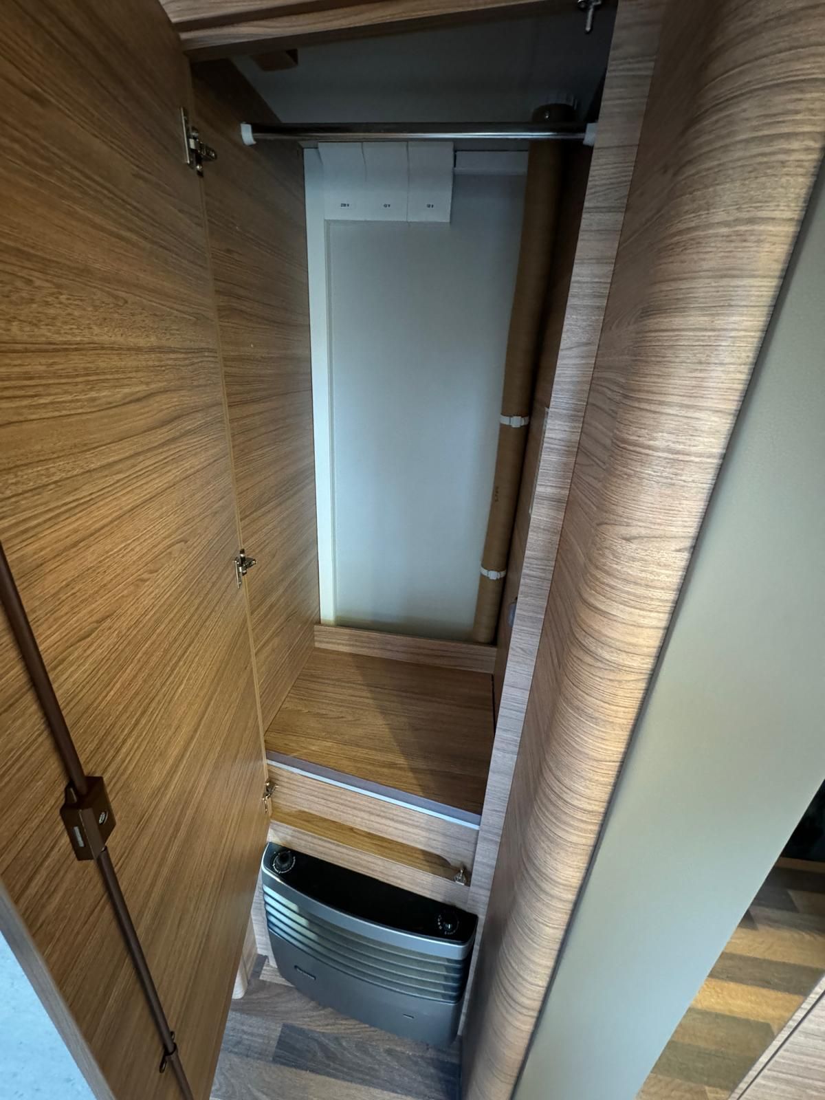 Ein Schrank mit offener Tür und einer Heizung darin.