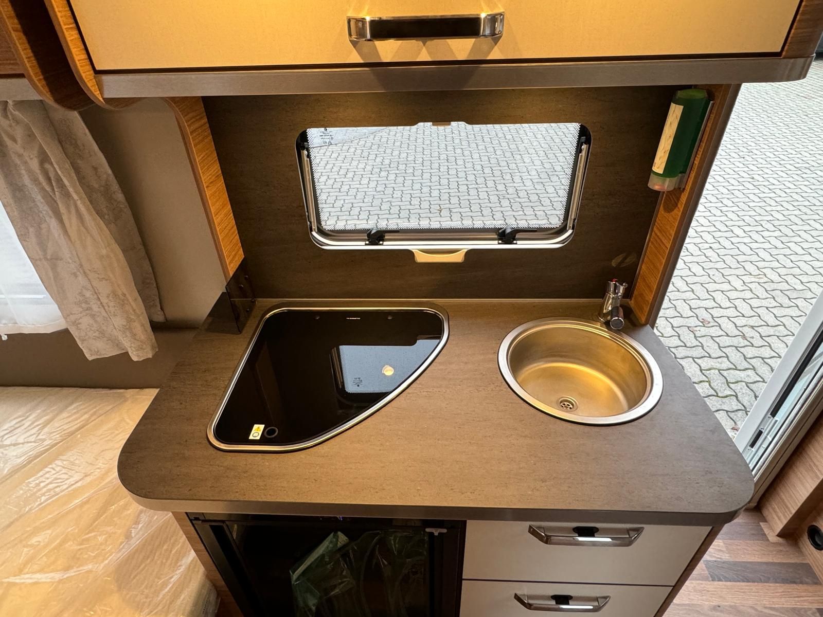 Eine Küche mit Spüle, Herd und Fenster.