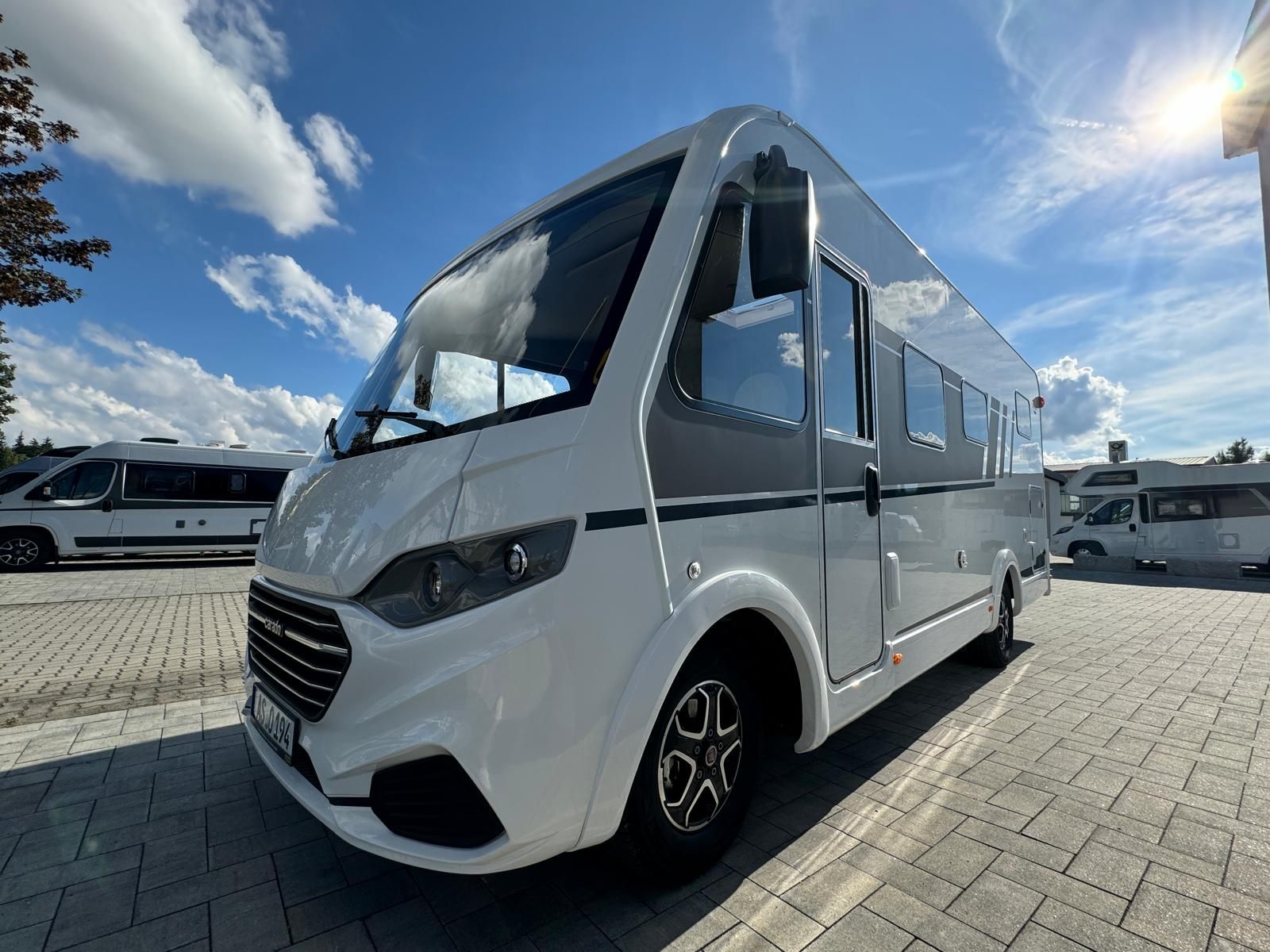 Ein weißes Wohnmobil steht auf einem Parkplatz.