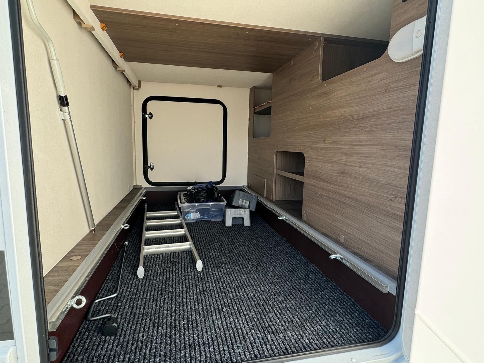 Das Innere eines Wohnmobils mit einer Leiter und einer Kiste darin.