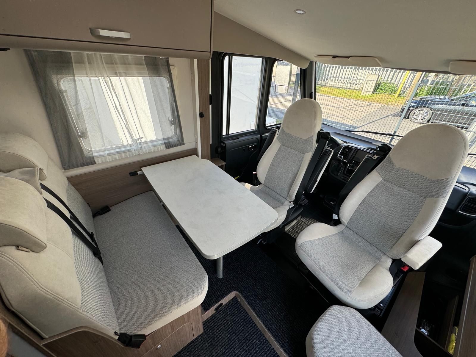 Das Innere eines Wohnmobils mit Tisch und Stühlen.