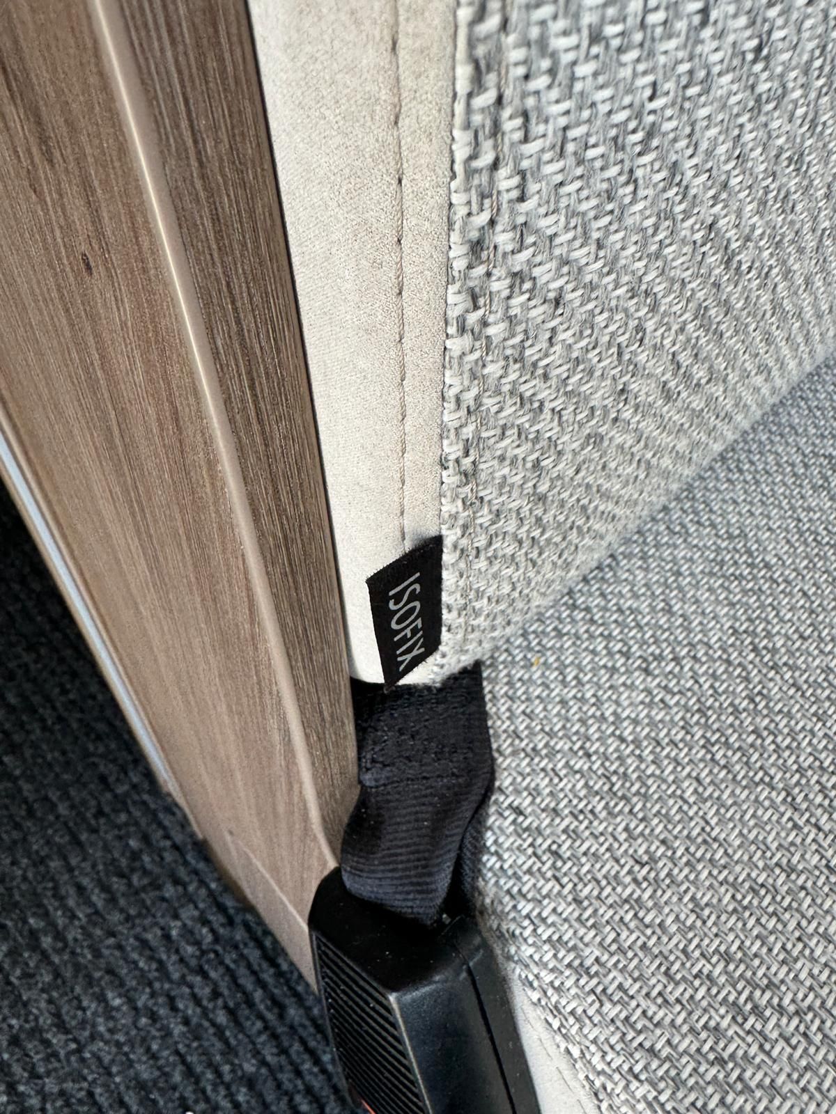 Eine Nahaufnahme eines Sicherheitsgurts auf einem Sofa neben einer Tür.