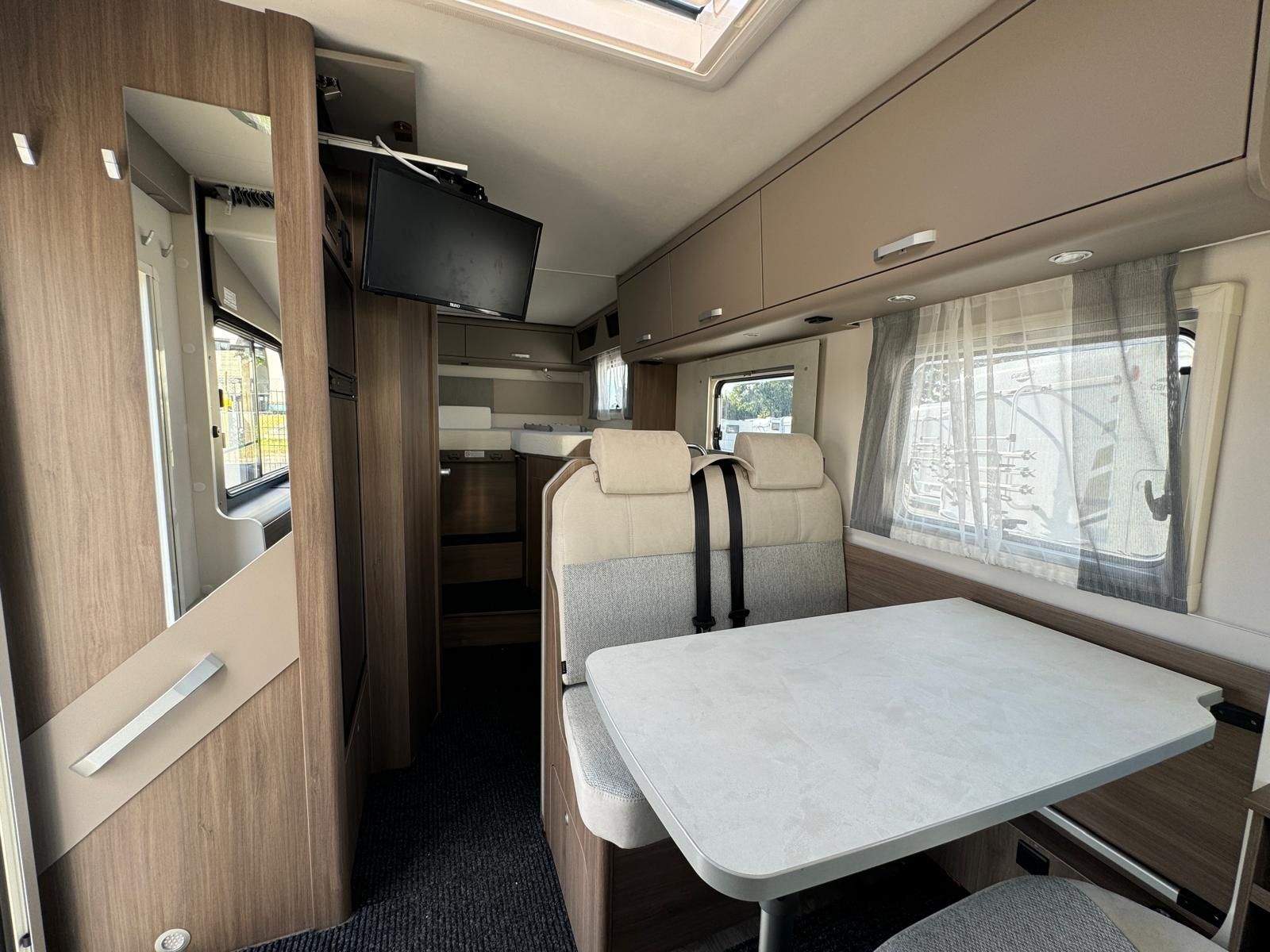 Das Innere eines Wohnmobils mit Tisch und Stühlen.